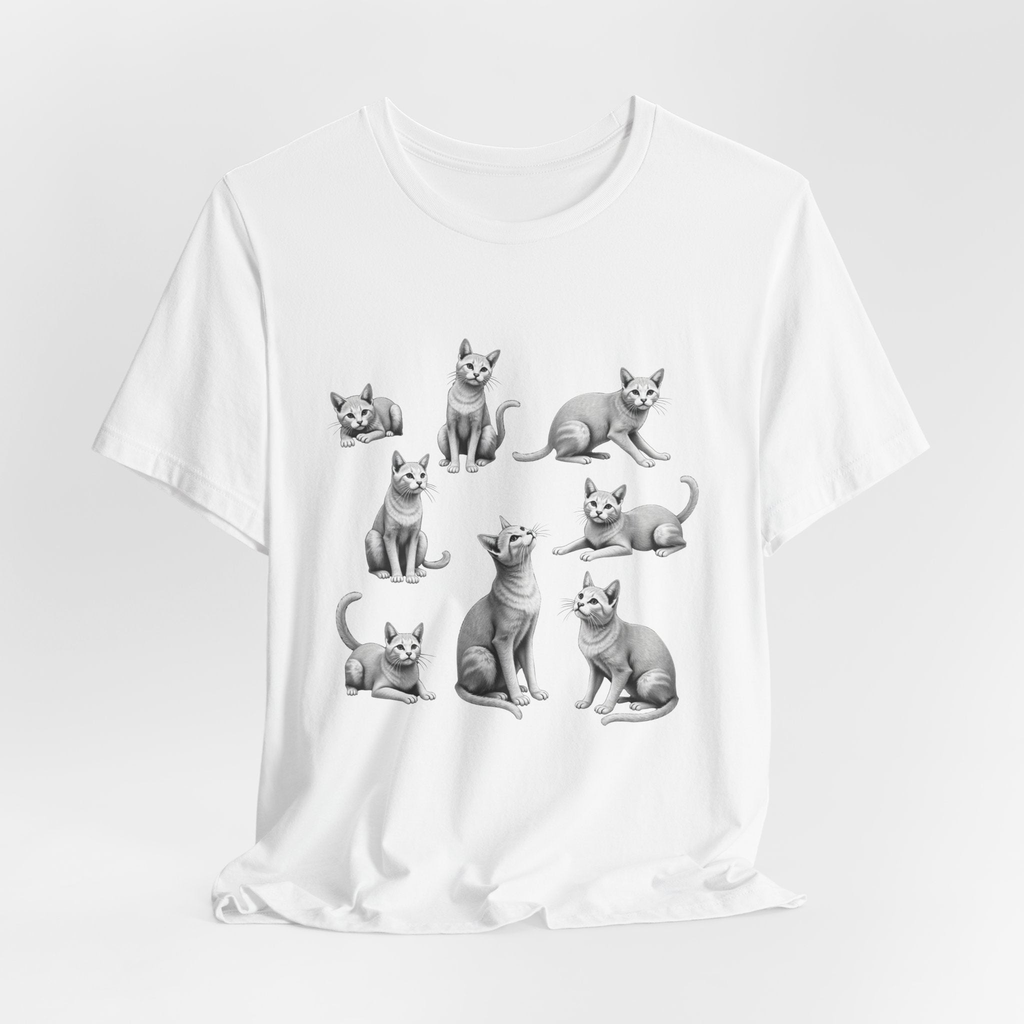 White t-shirt with black and white cat illustrations on a light gray background