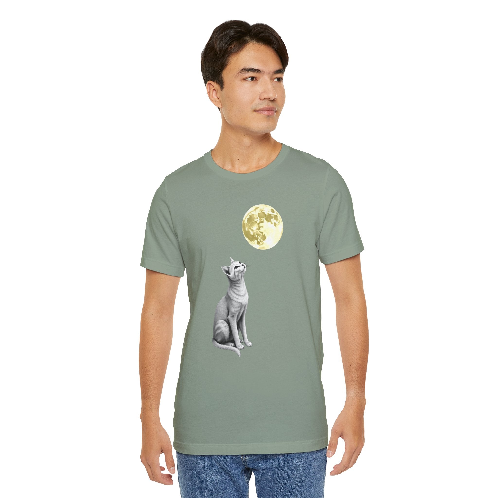 Person wearing a green t-shirt with a graphic of a dog and moon on a white background
