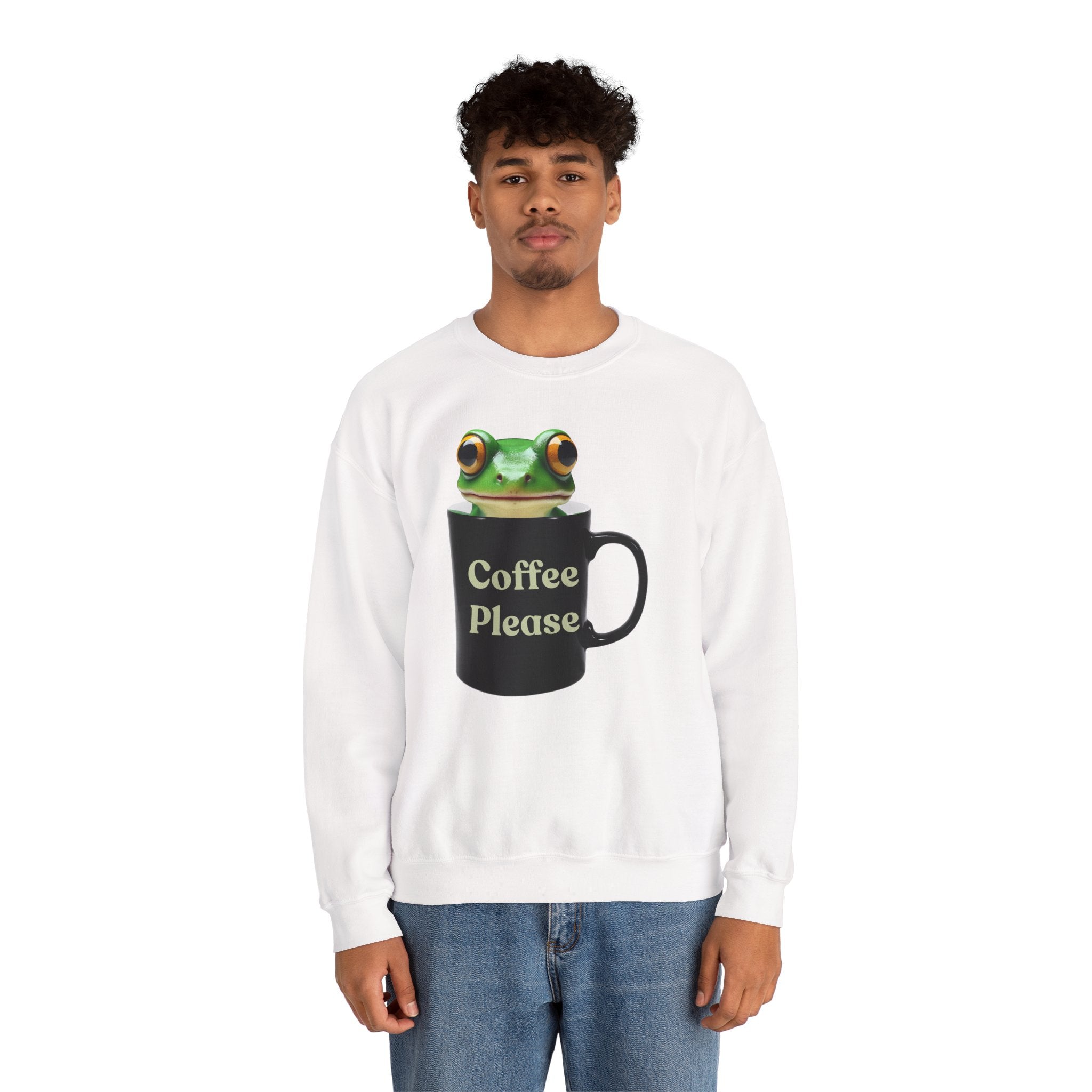 Person wearing a white sweatshirt with a frog design holding a coffee mug on a white background