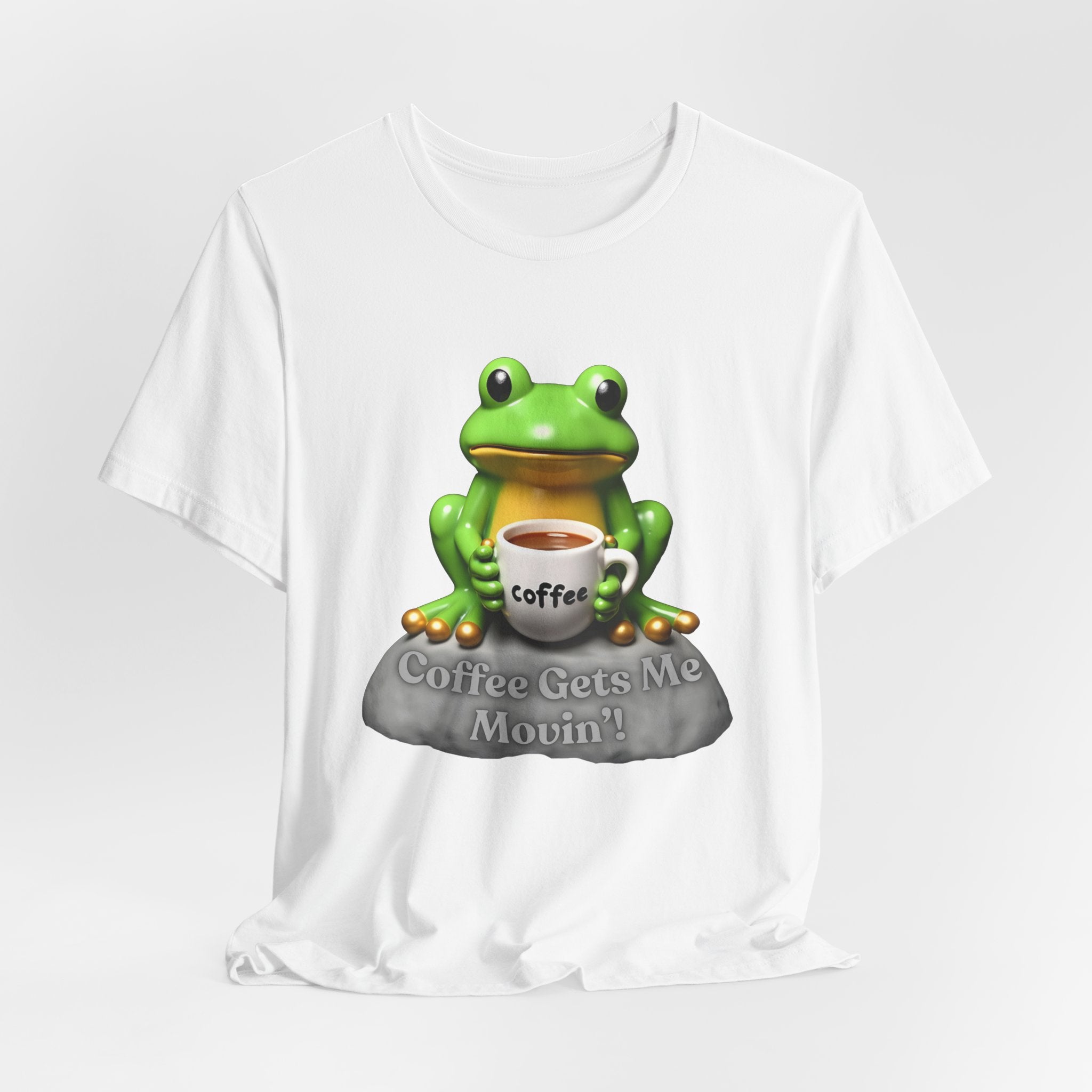 White t-shirt with a green frog holding a coffee cup and 'Coffee Gets Me Movin'' text on a white background