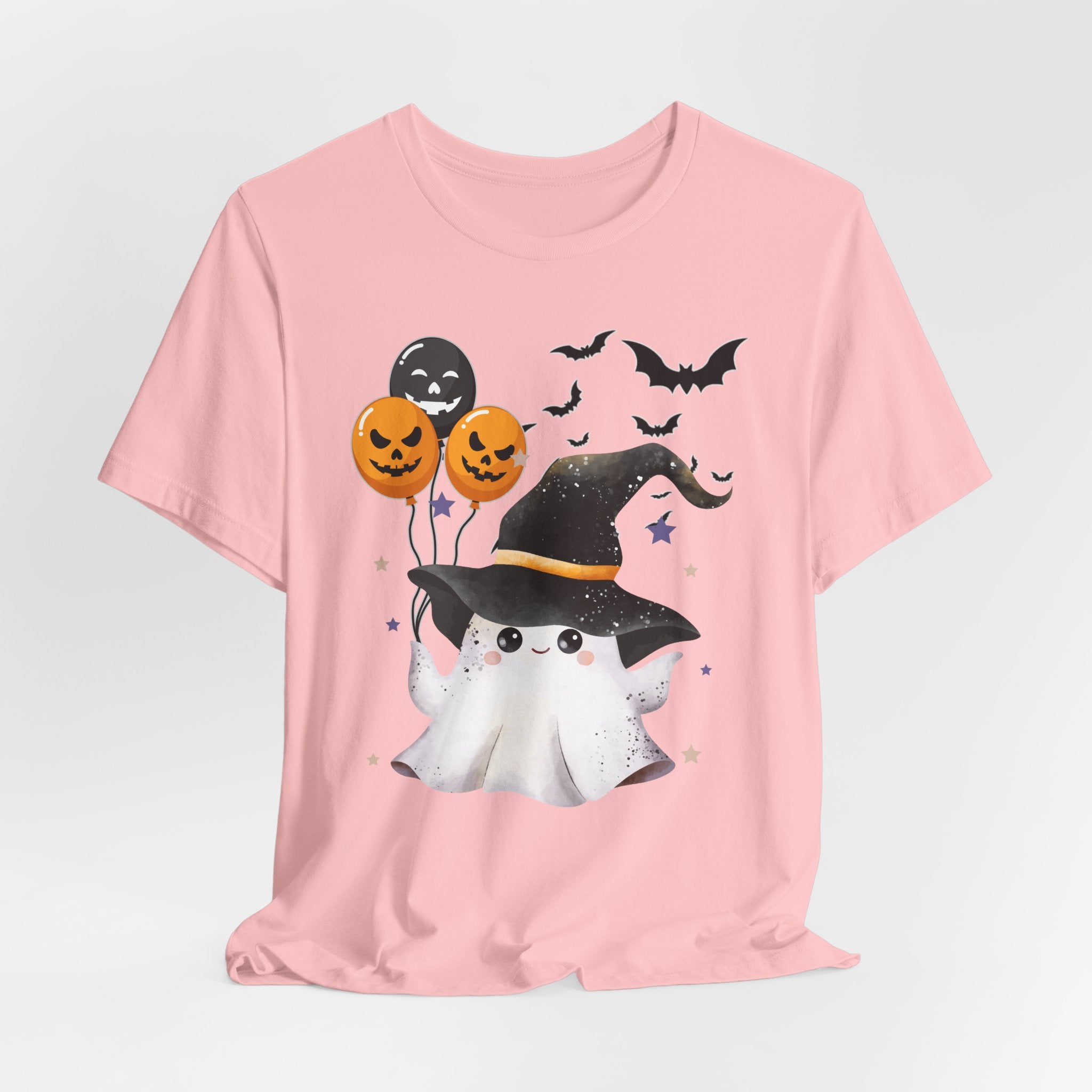 Pink t-shirt with Halloween-themed design featuring a ghost, pumpkins, and bats on a light gray background.