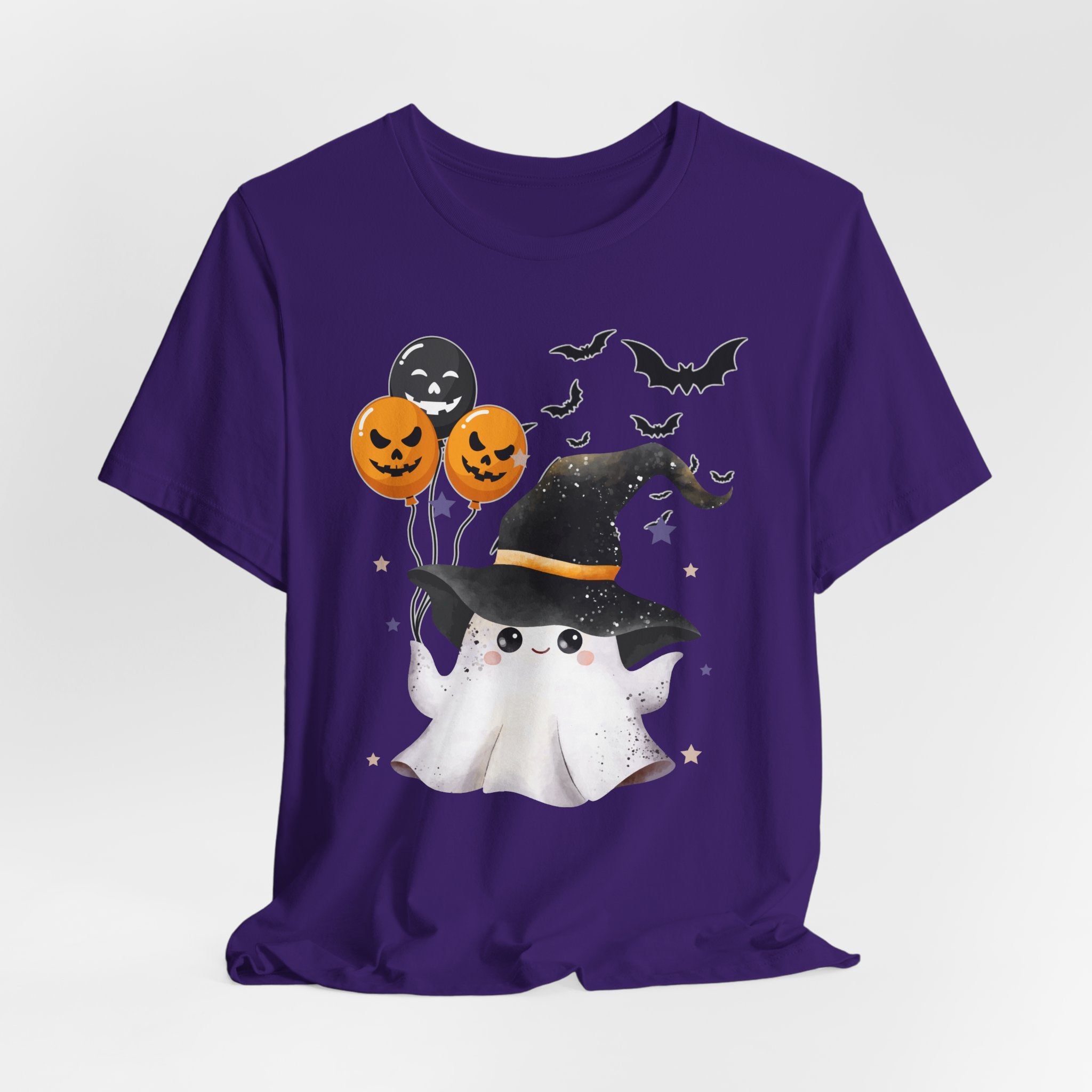 Purple t-shirt with Halloween-themed design featuring a ghost, witch hat, and balloons on a white background.