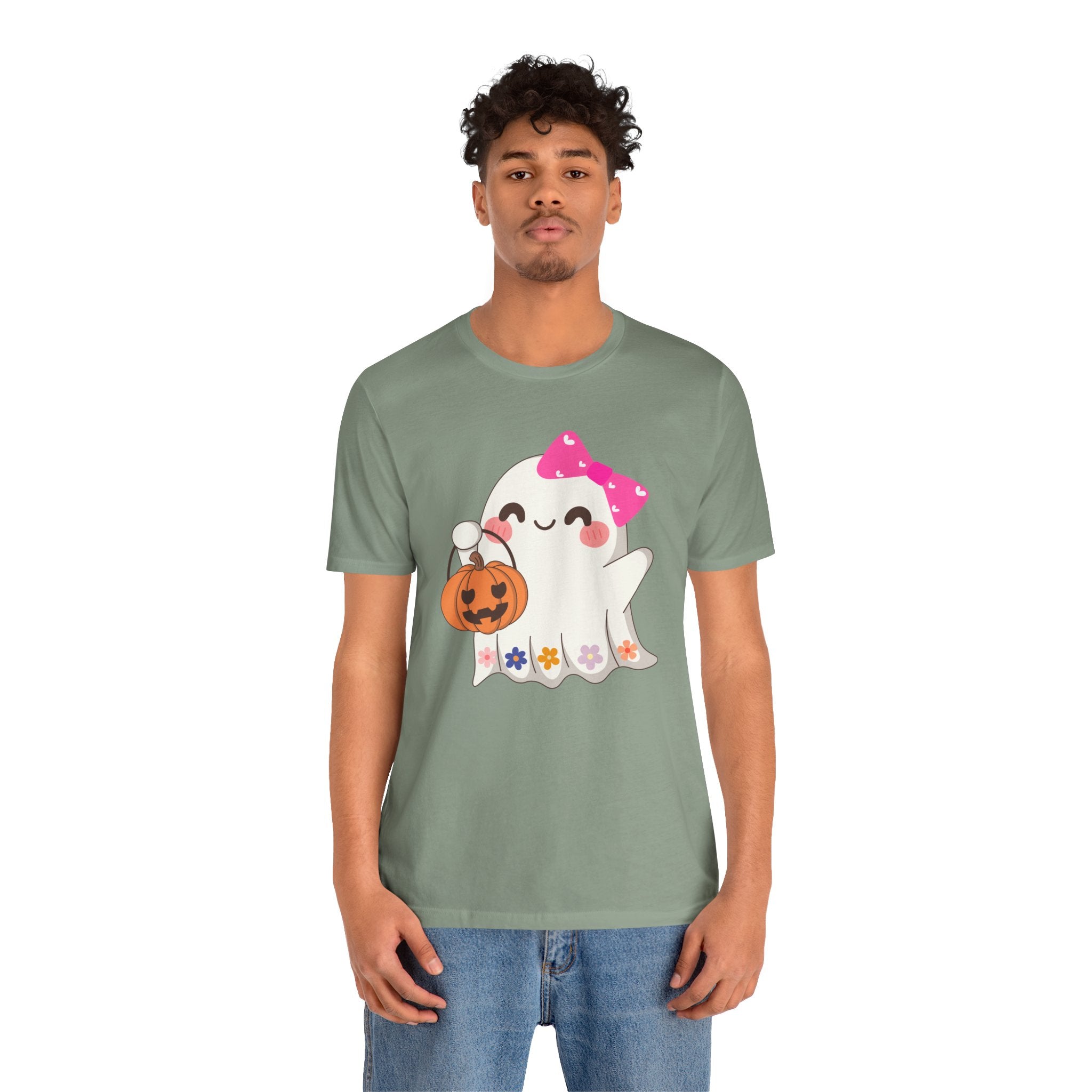 Person wearing a green t-shirt with a cartoon ghost design on a white background