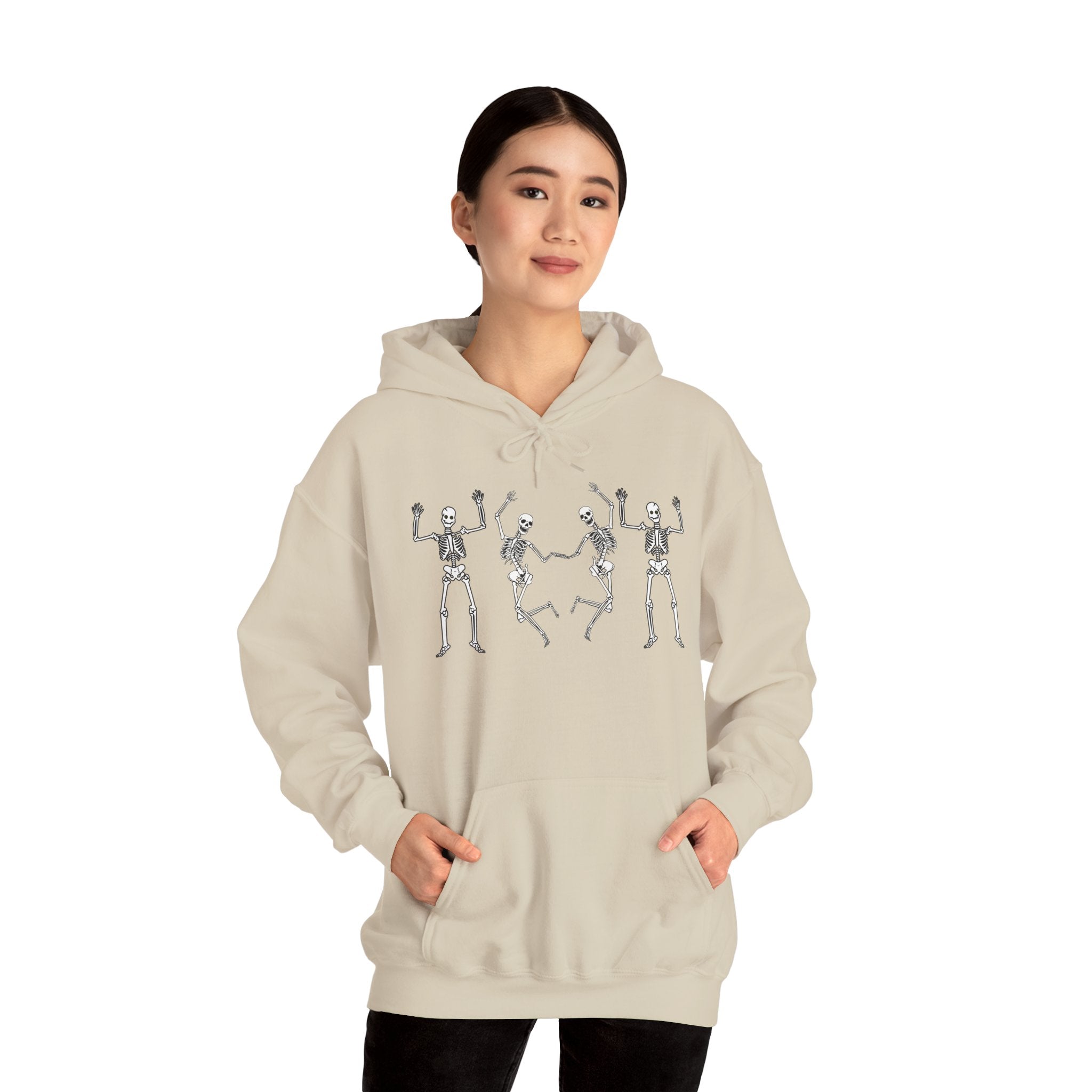 Person wearing a beige hoodie with skeleton designs on a white background
