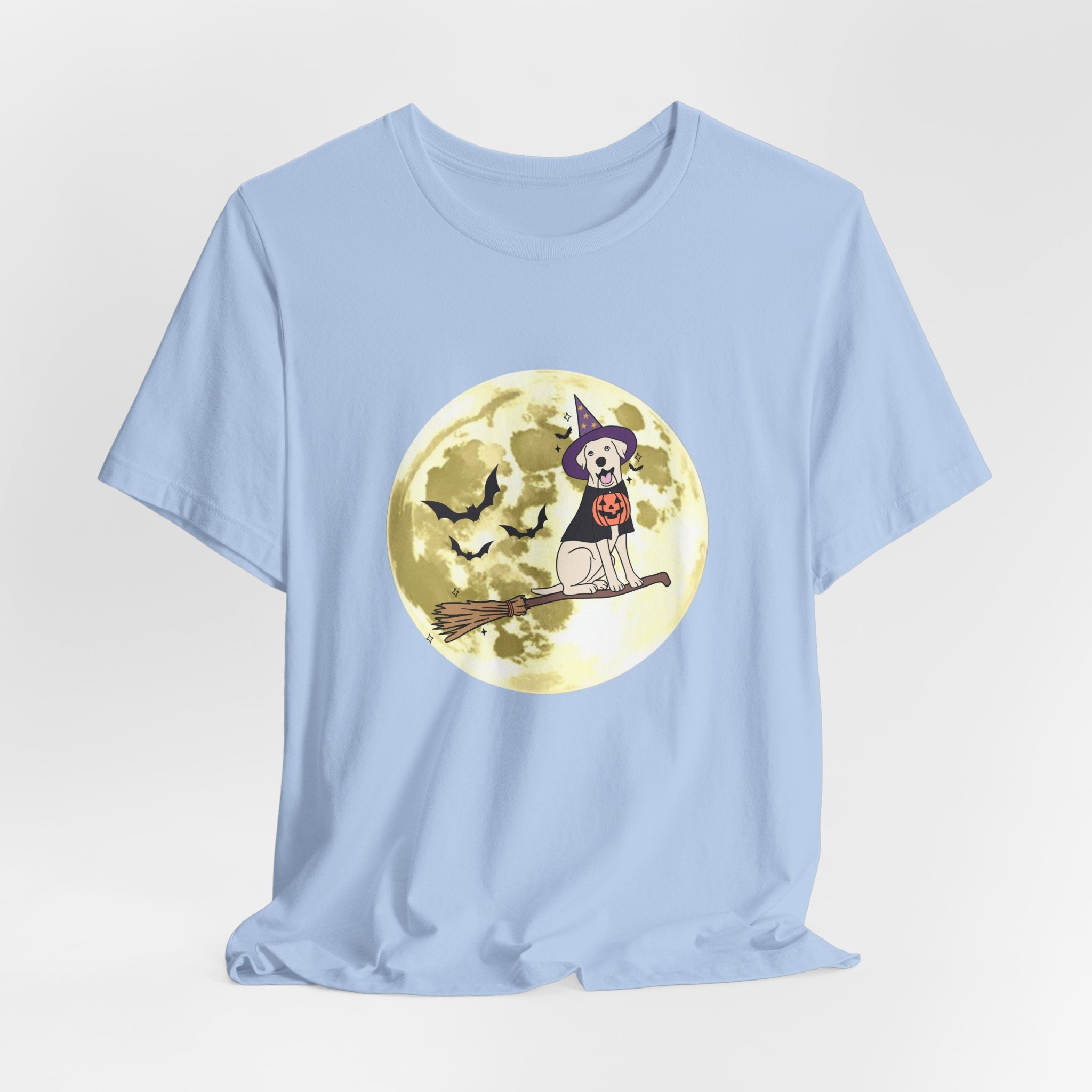 Light blue t-shirt with Halloween design featuring bats and a dog in a witch hat and pumpkin on a broomstick against a moonlit sky.