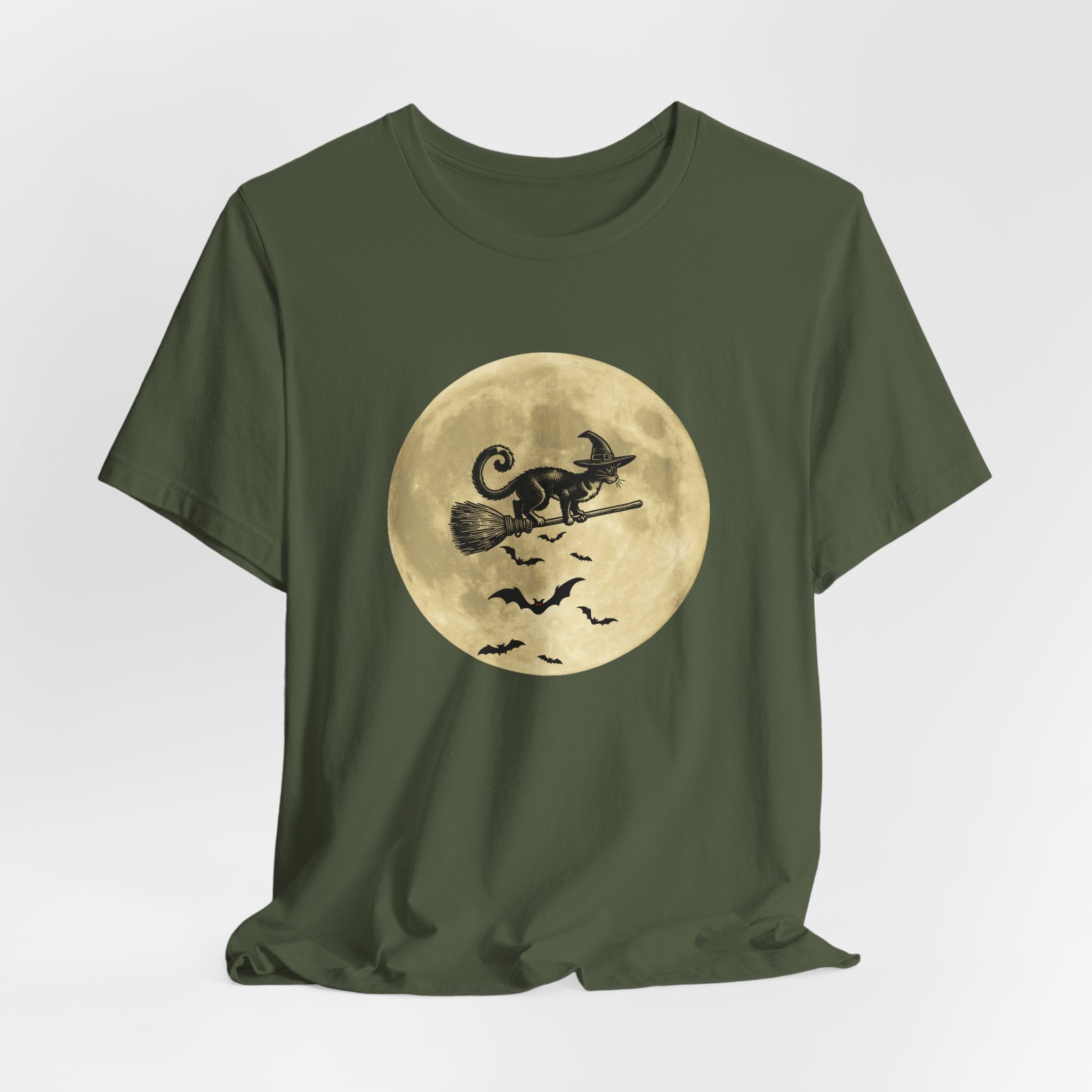 Military green t-shirt with a graphic of a cat on a broomstick against a moon background on a white background