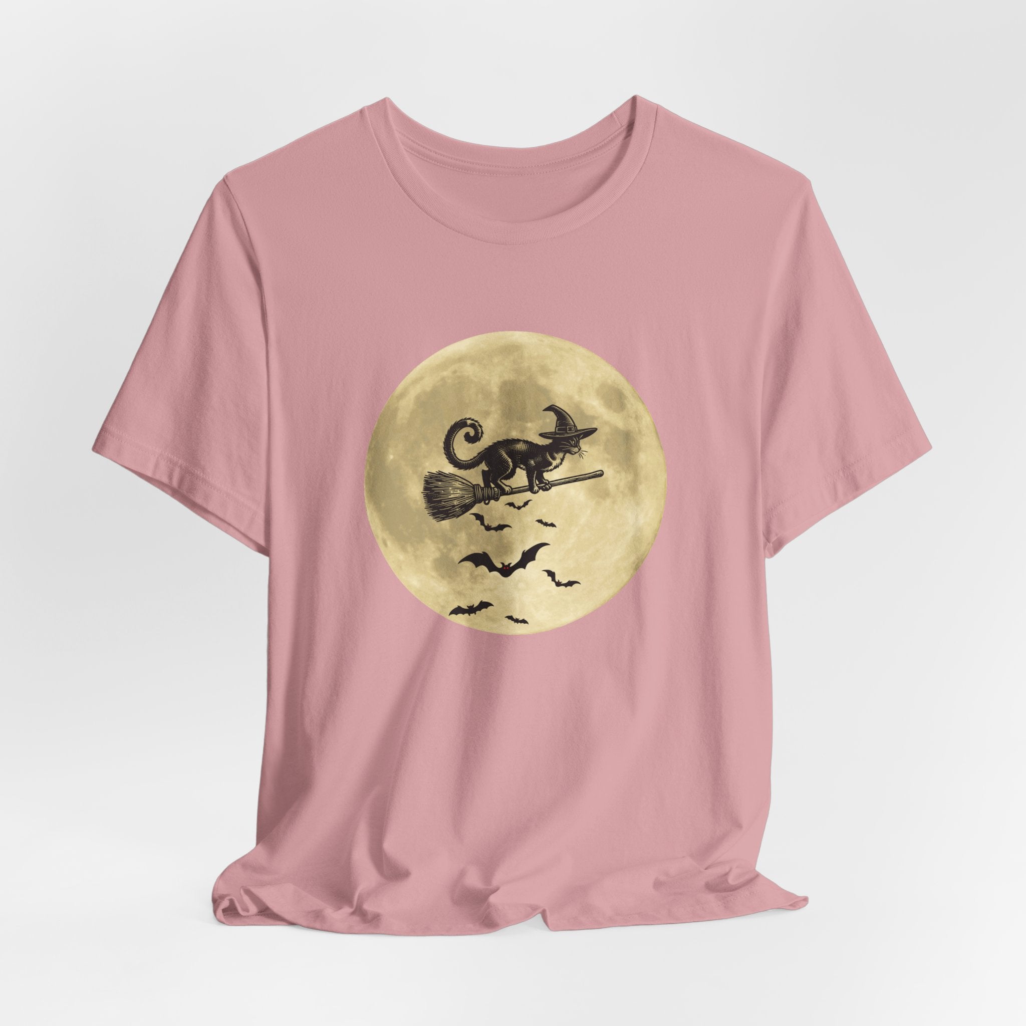 Orchid pink t-shirt with a Halloween design of a cat on a broomstick against a full moon on a light gray background.