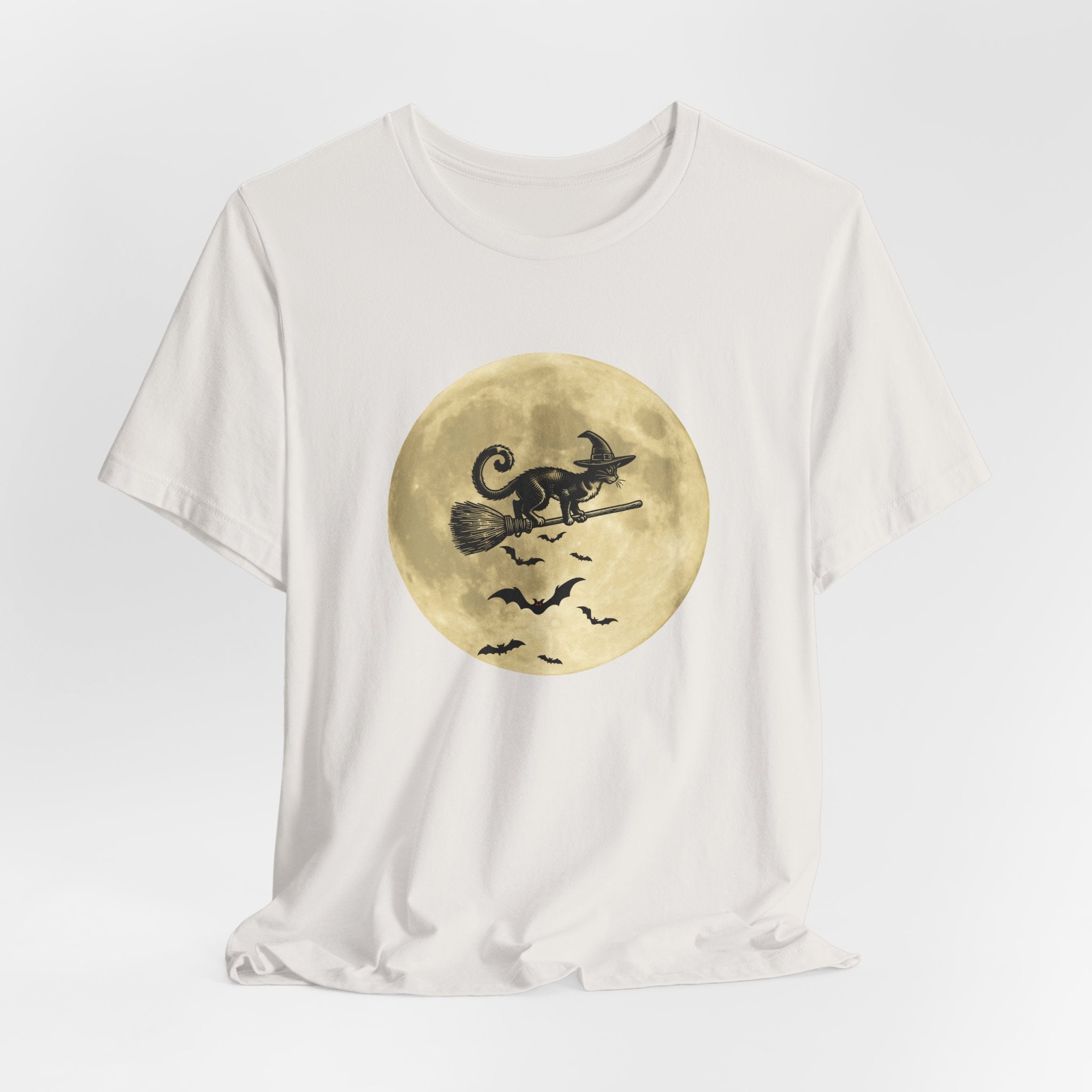 Vintage white t-shirt with a Halloween-themed graphic of a cat on a broomstick against a gold moon.