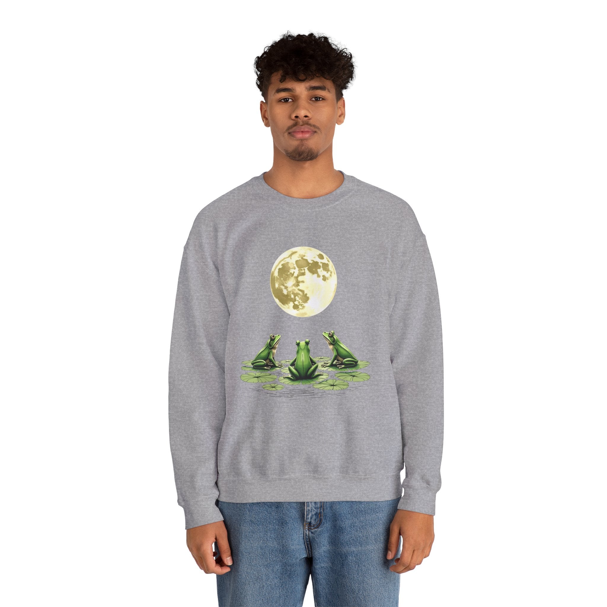 Person wearing a gray sweatshirt with a graphic of three frogs and a moon on a white background