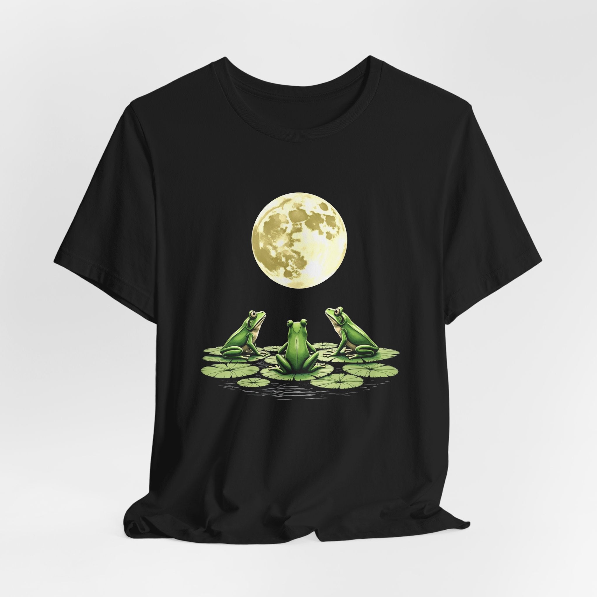 Black t-shirt featuring cute frogs sitting on top of water lily watching on the moon graphic on a white background