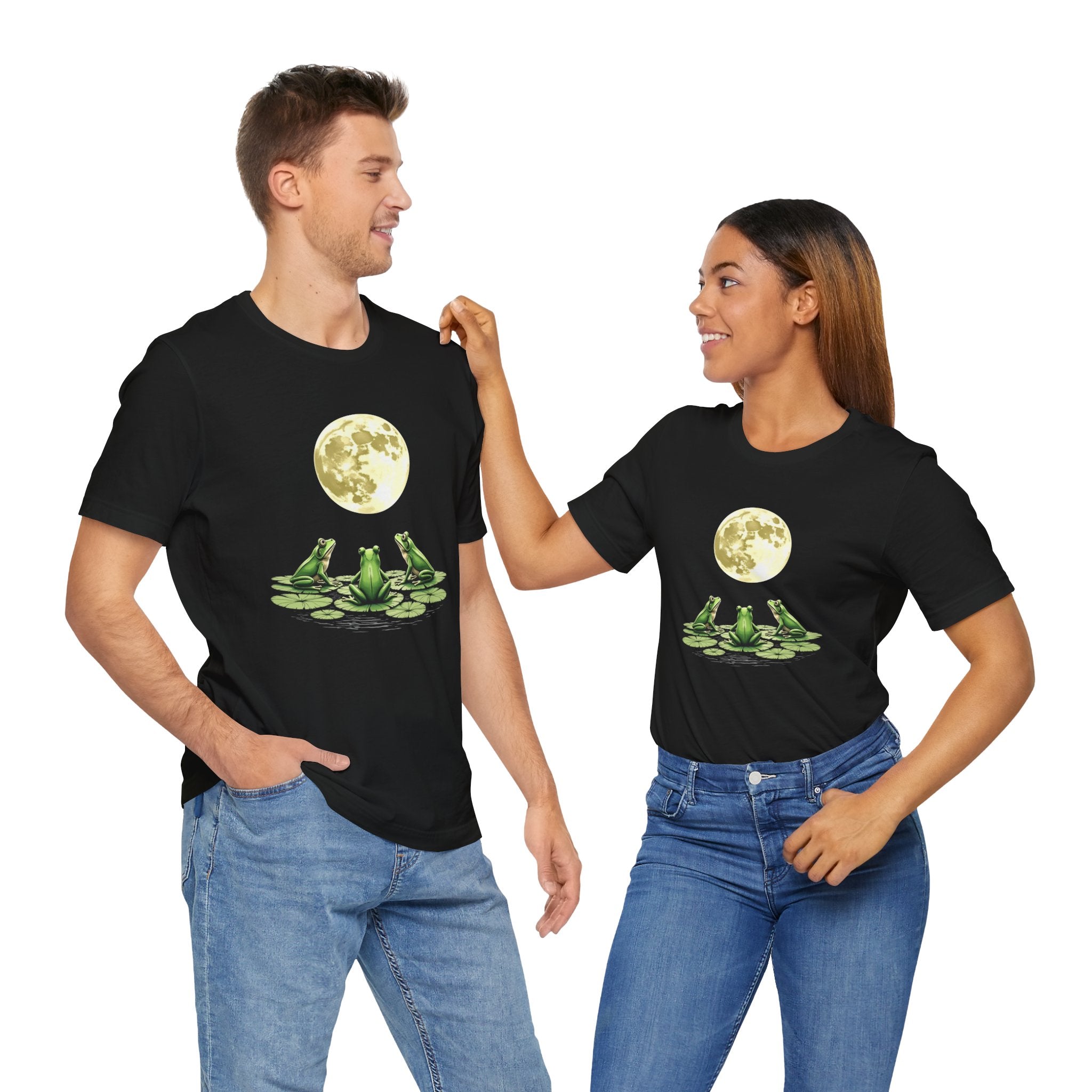 Two people wearing black t-shirts with a graphic design of frogs and a moon.