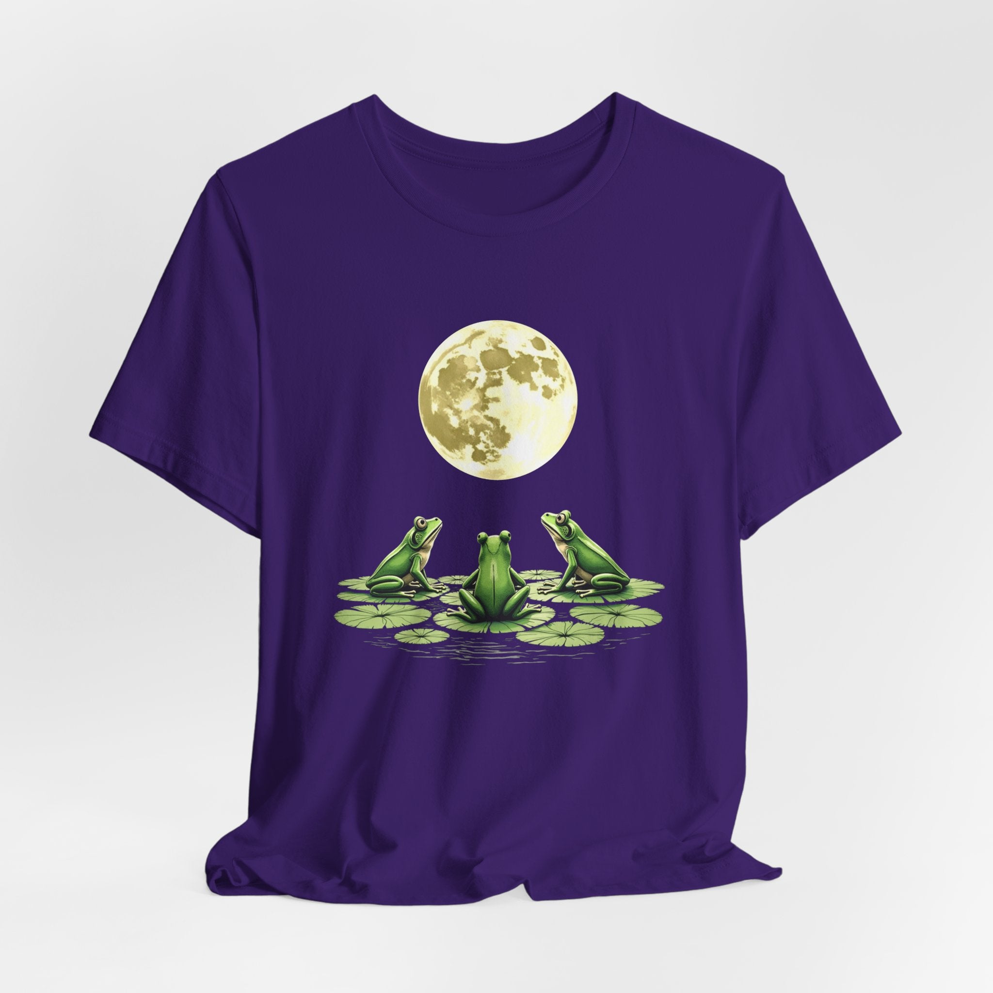 Team purple t-shirt featuring cute frogs sitting on top of water lily watching on the moon graphic on a white background