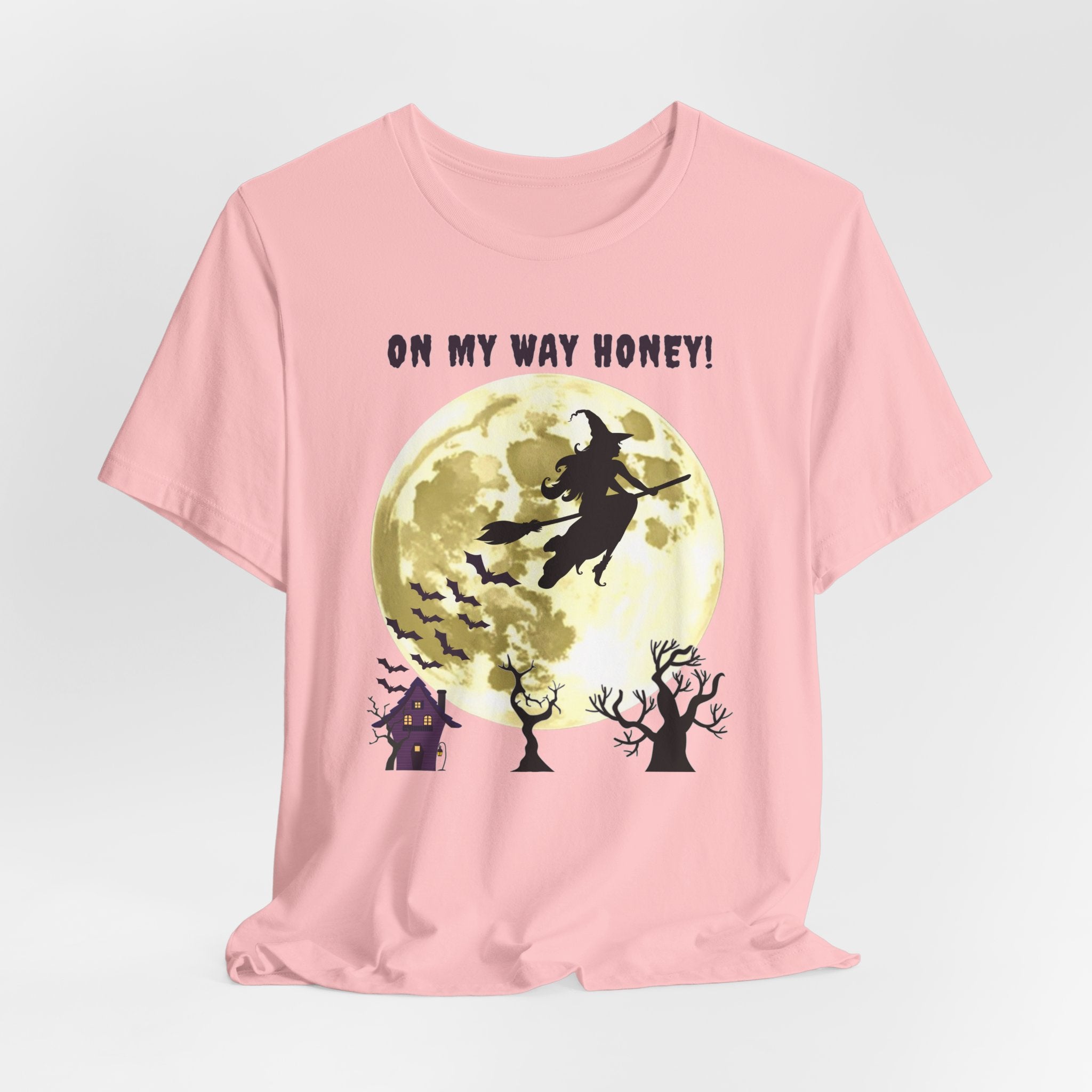 Pink t-shirt with Halloween design featuring a witch and moon on a light gray background