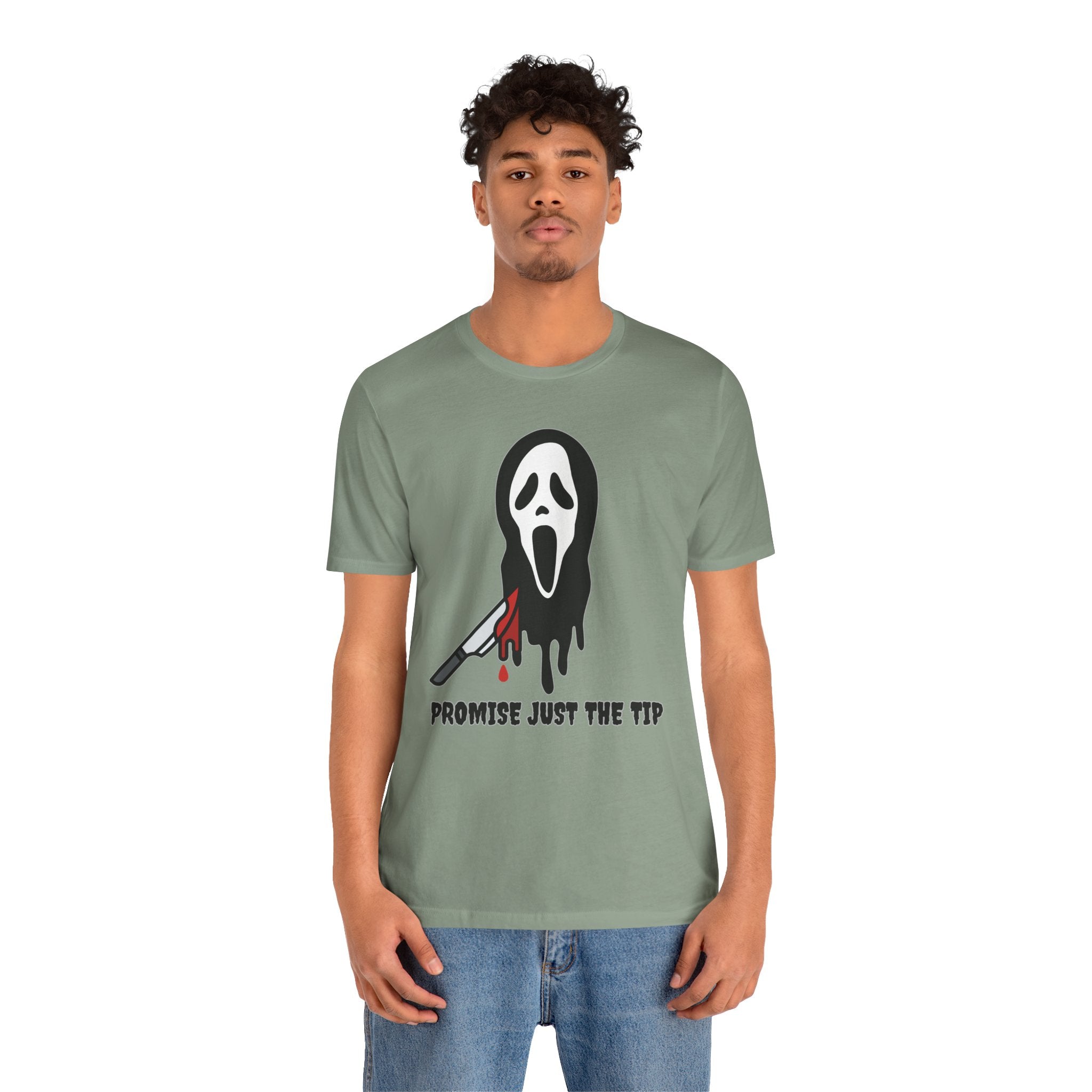 Person wearing a green t-shirt with a graphic design on a white background