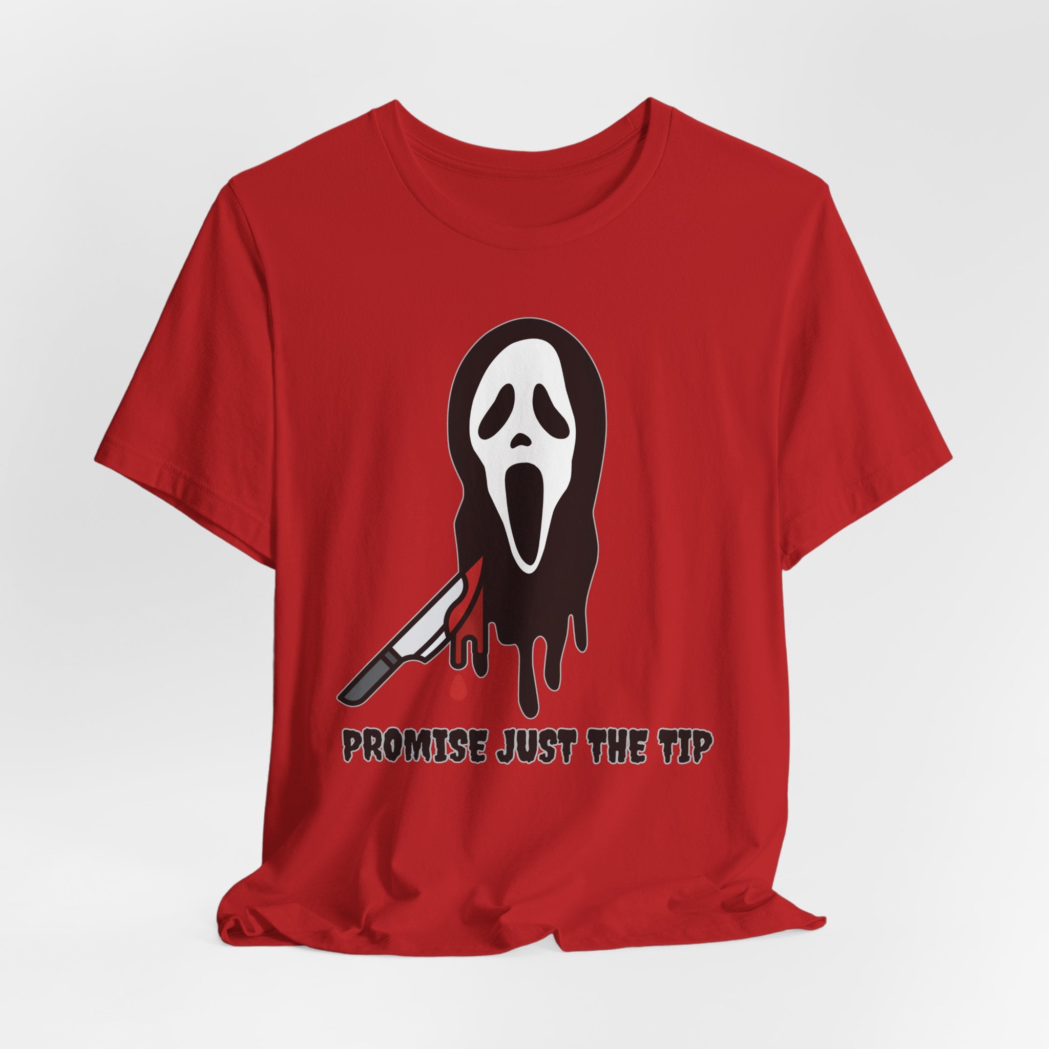 Red t-shirt with a graphic design of a face with a knife and text 'Promise Just the Tip' on a white background.