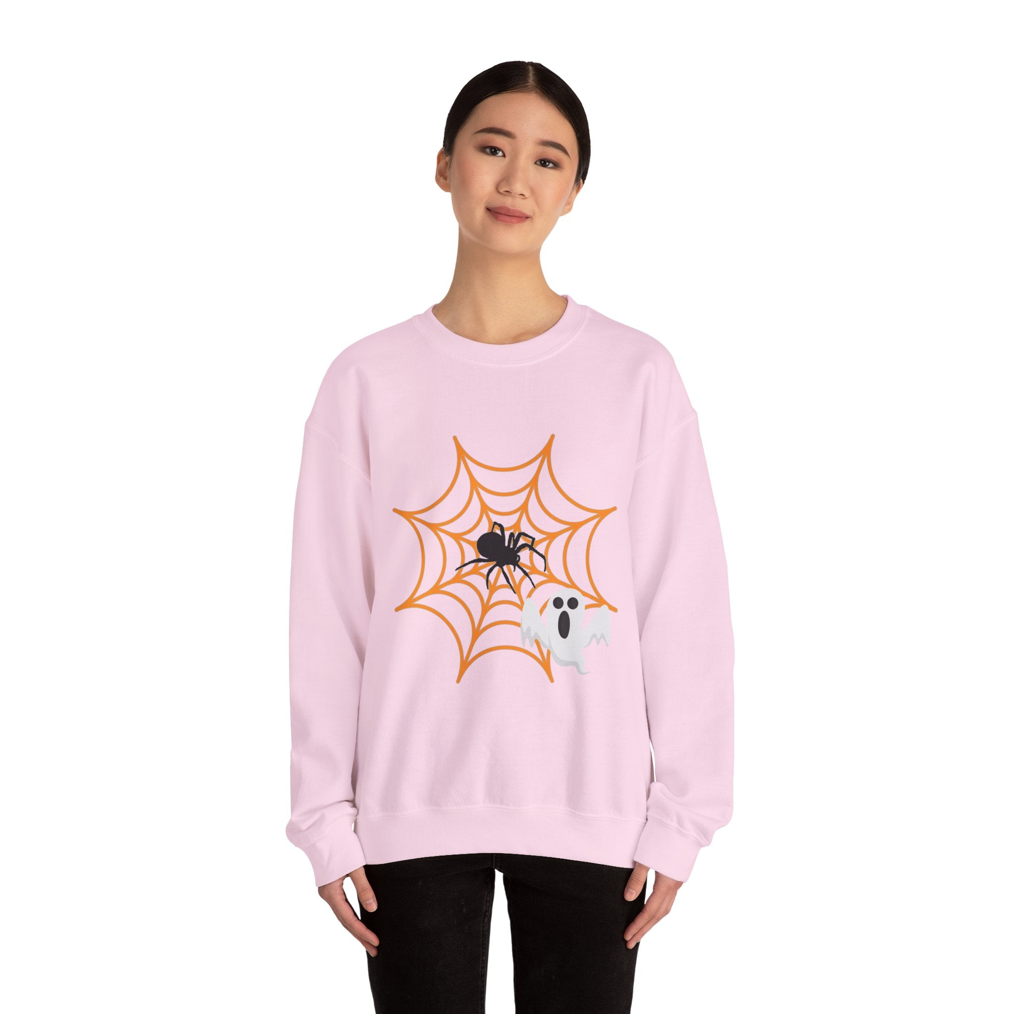 Person wearing a pink sweatshirt with a spider and ghost design on a white background