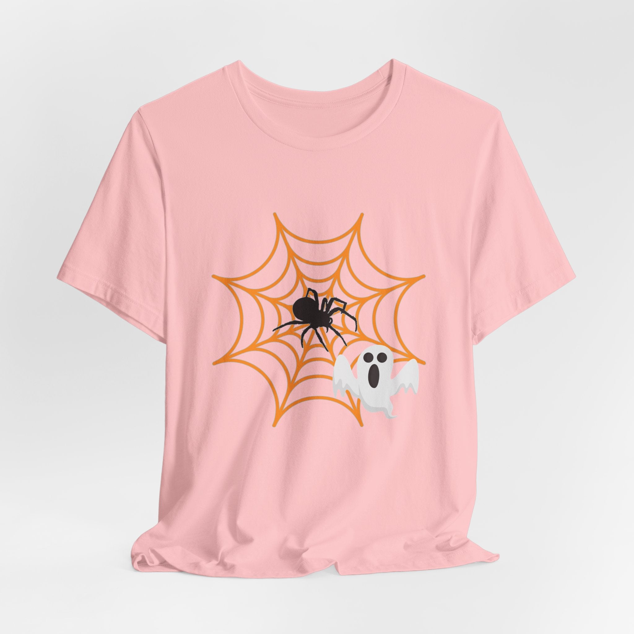 Pink t-shirt with Halloween design featuring a spider, web, and ghost on a light gray background