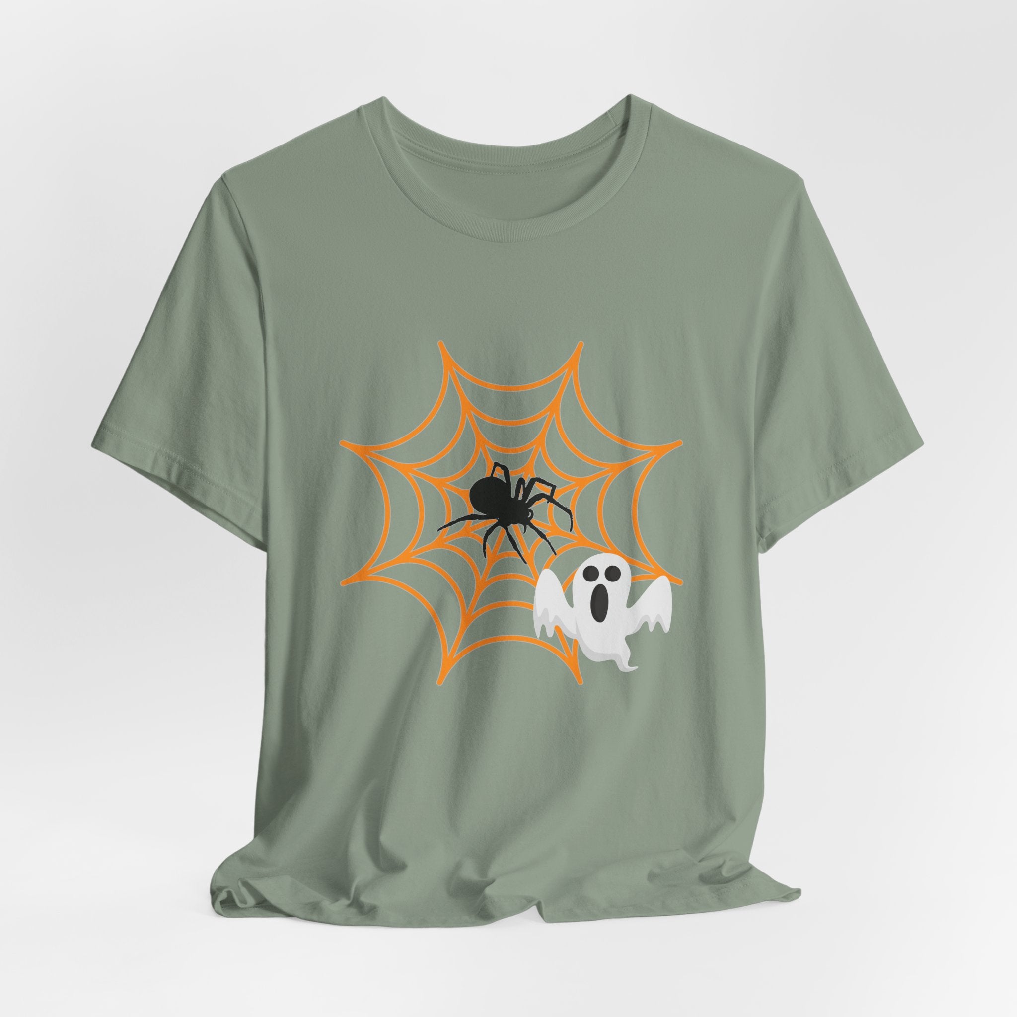 Sage green t-shirt with Halloween design of a spider, web, and ghost on a white background
