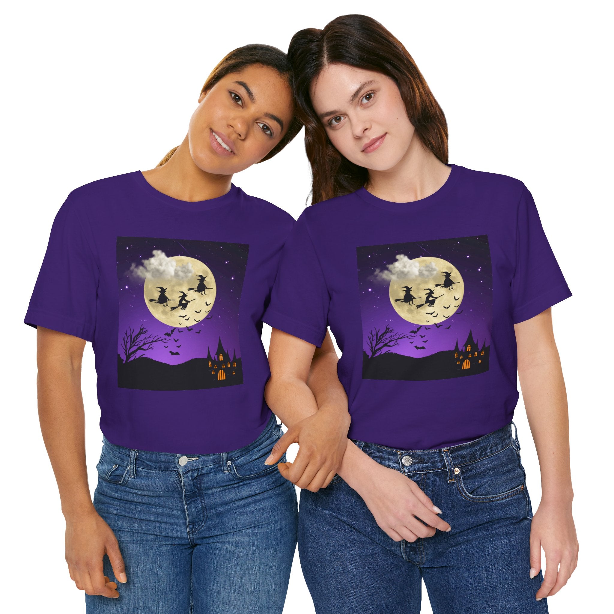 Two people wearing purple t-shirts with a Halloween design featuring a full moon, ghosts, and a witch.