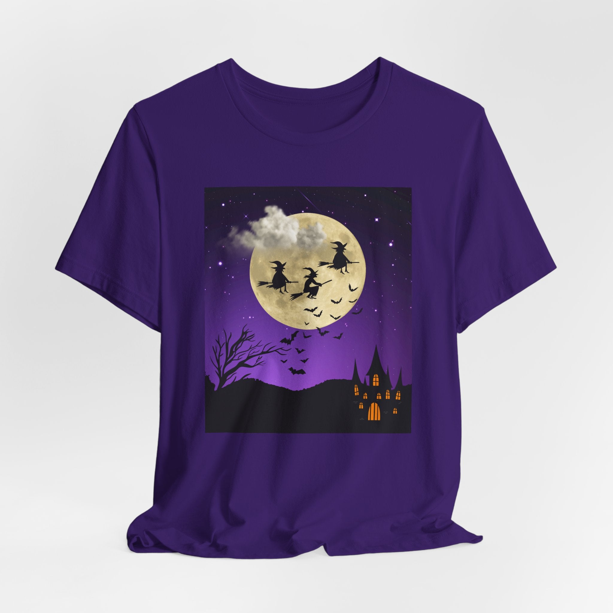 Purple t-shirt with Halloween-themed design featuring witches flying over a moonlit sky.
