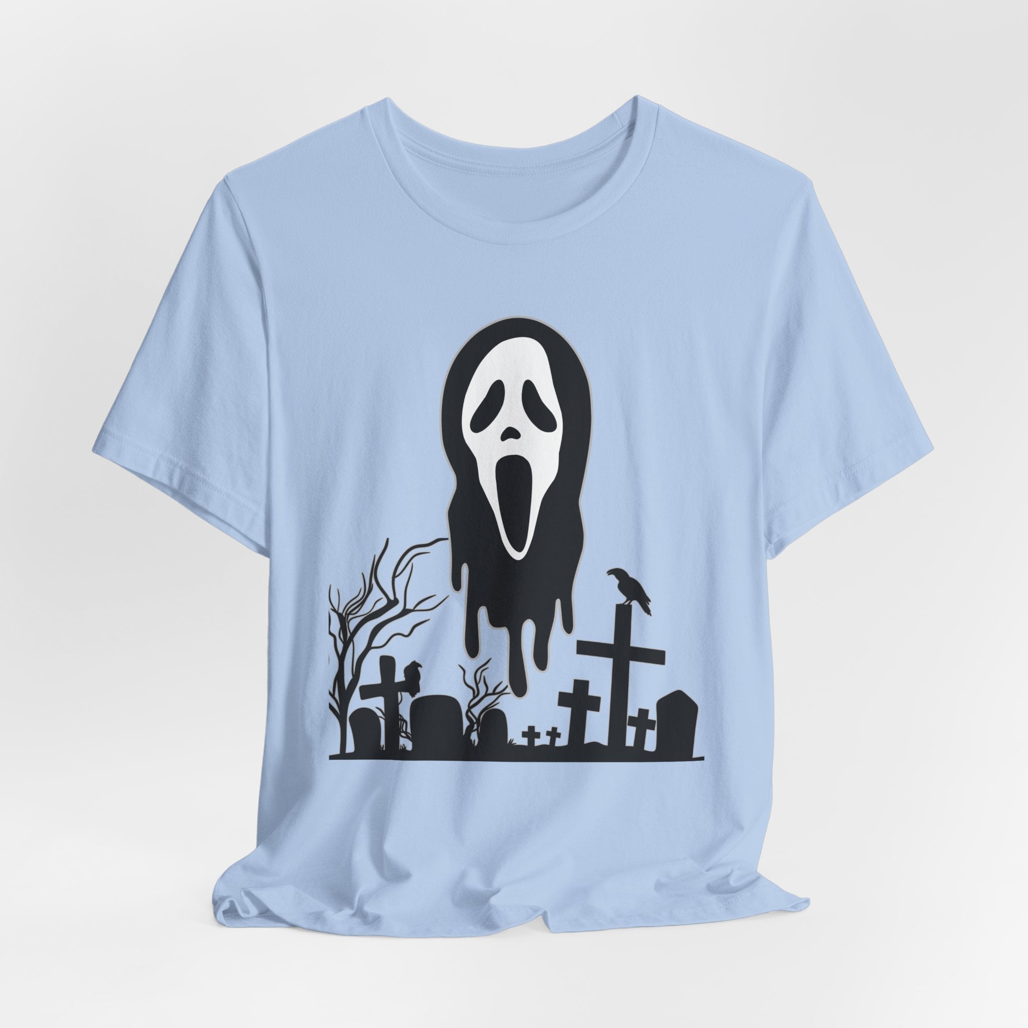 Light blue t-shirt with a Halloween-themed graphic of a ghost face and graveyard on a white background