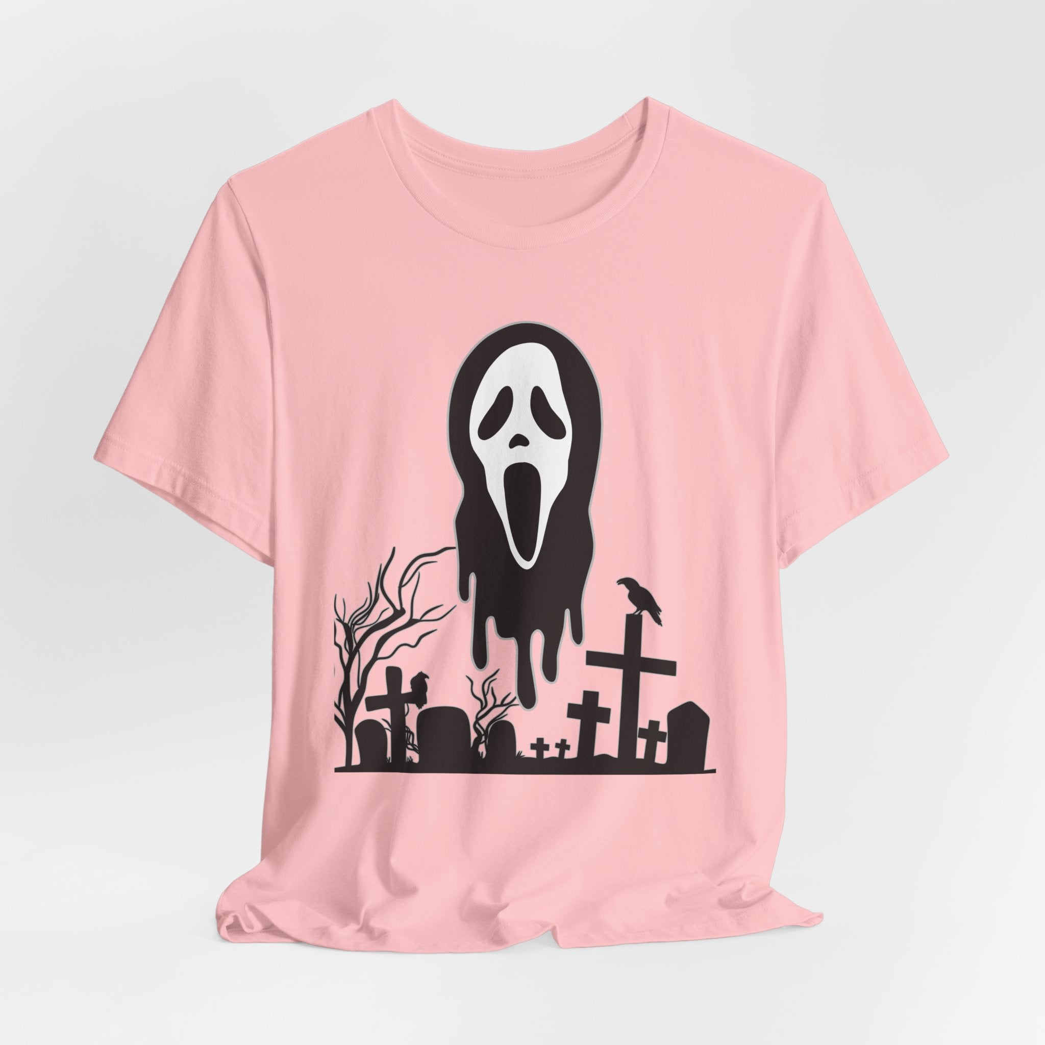 Pink t-shirt with a black graphic of a ghost face and graveyard on a white background