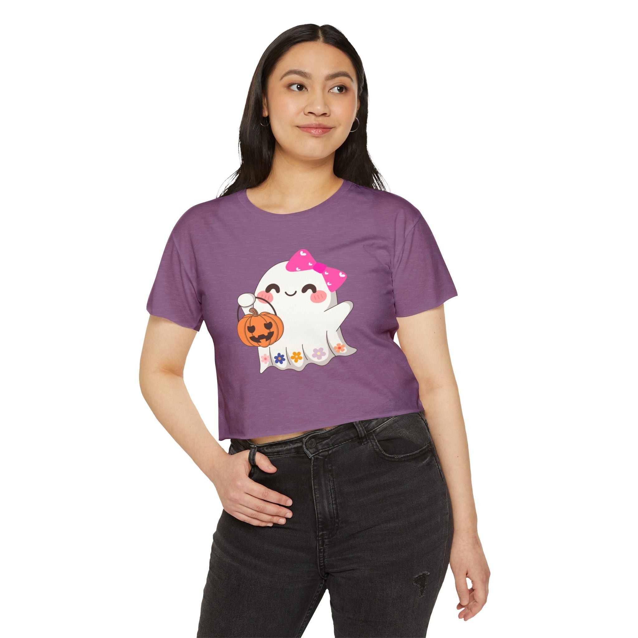 Person wearing a purple t-shirt with a ghost and pumpkin design on a white background