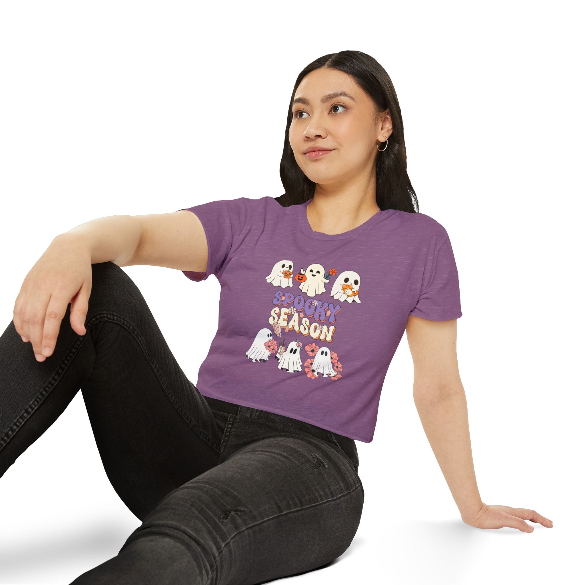 Woman wearing a purple t-shirt with Halloween-themed graphics and text.