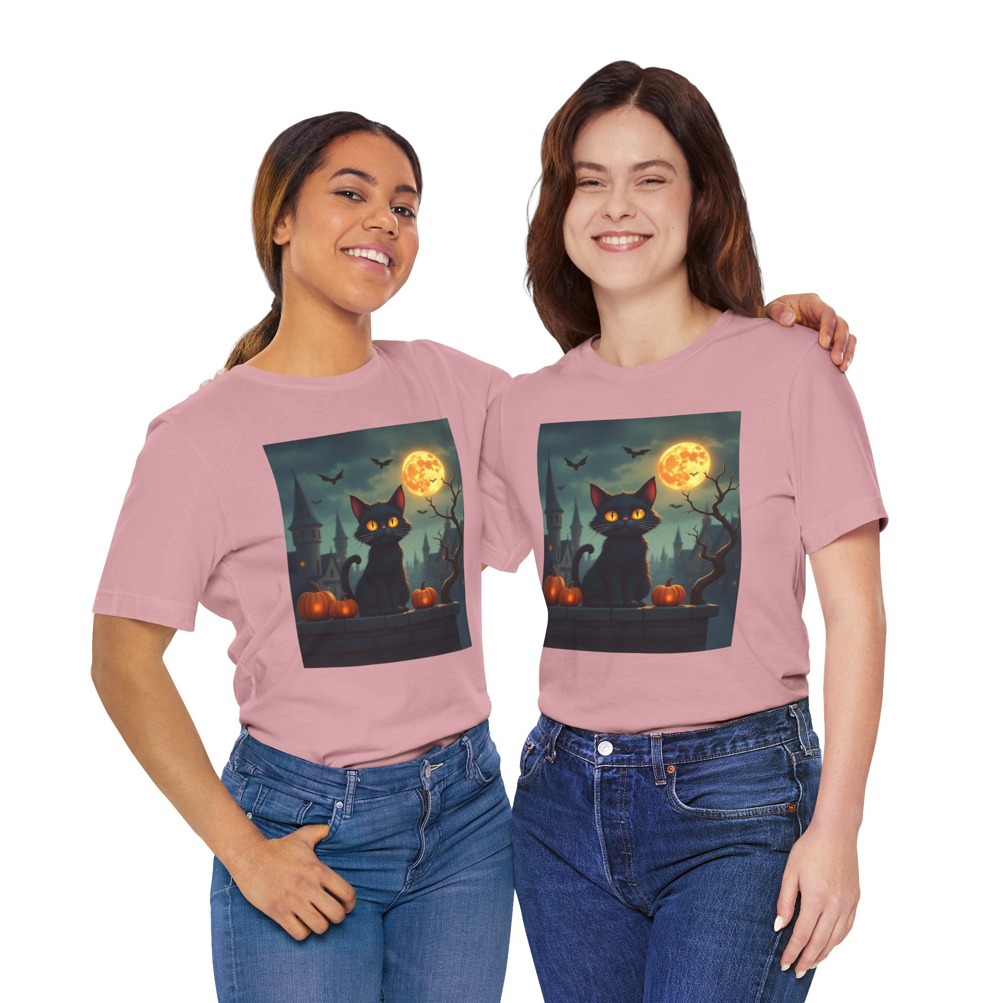 Two people wearing pink t-shirts with a Halloween design featuring a black cat, full moon, and pumpkins.