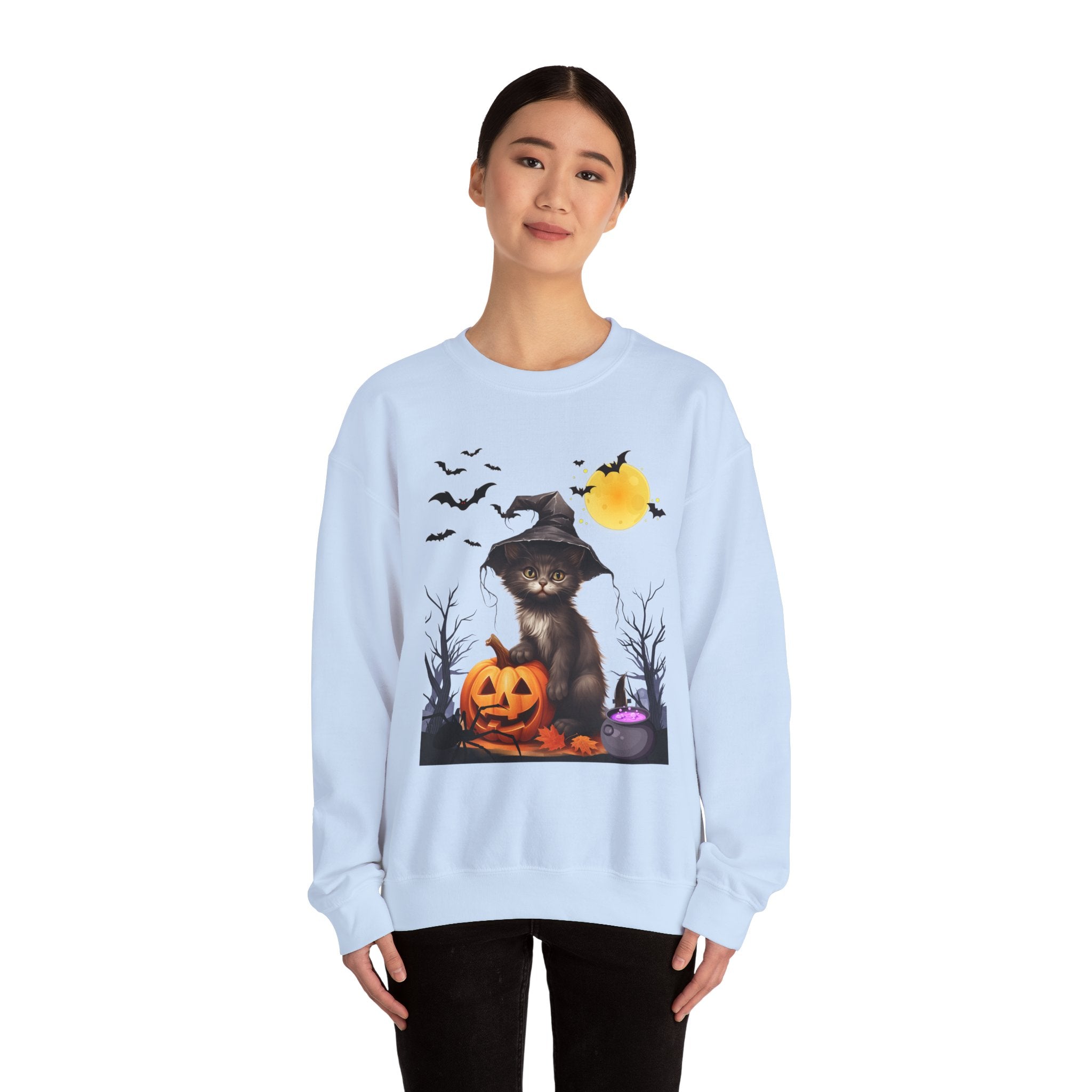 Person wearing a light blue sweatshirt with a Halloween-themed design featuring a cat in a witch hat, pumpkin, and bats.