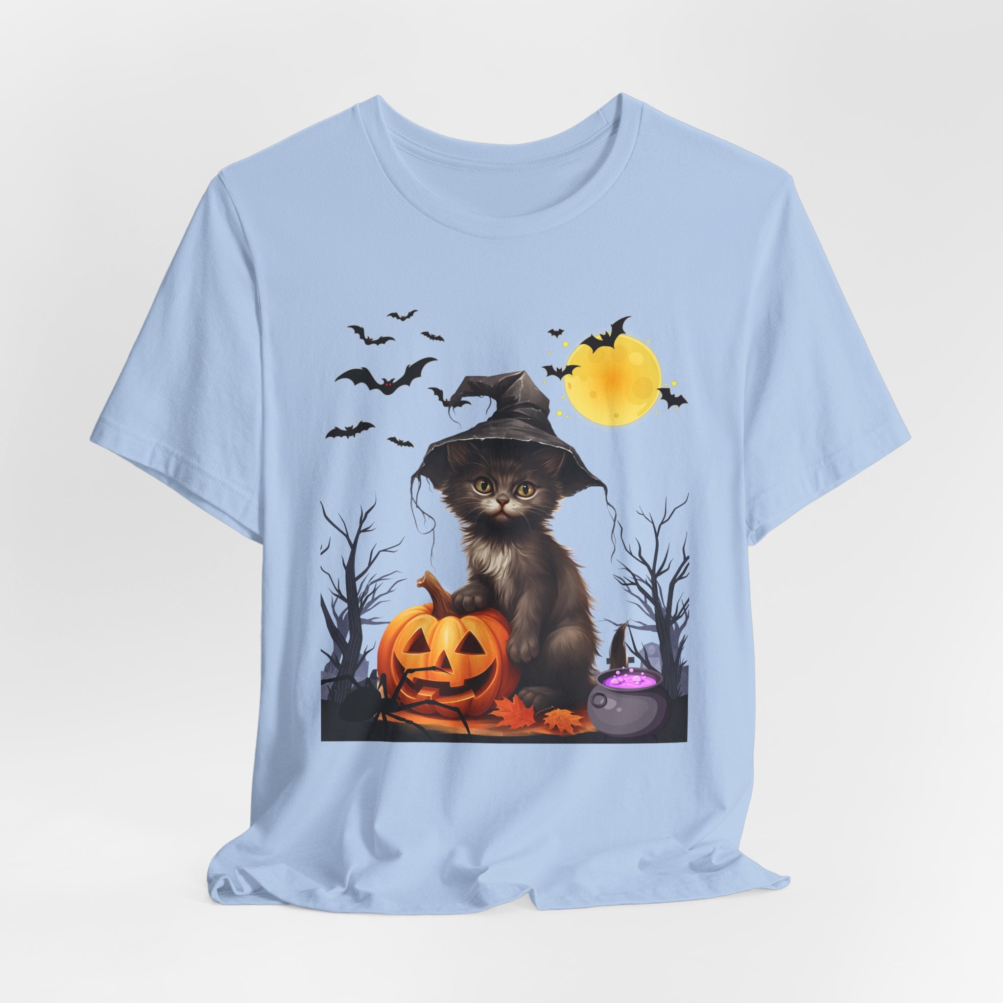 Light blue t-shirt with a Halloween-themed design featuring a cat in a witch hat, pumpkins, and bats on a white background.
