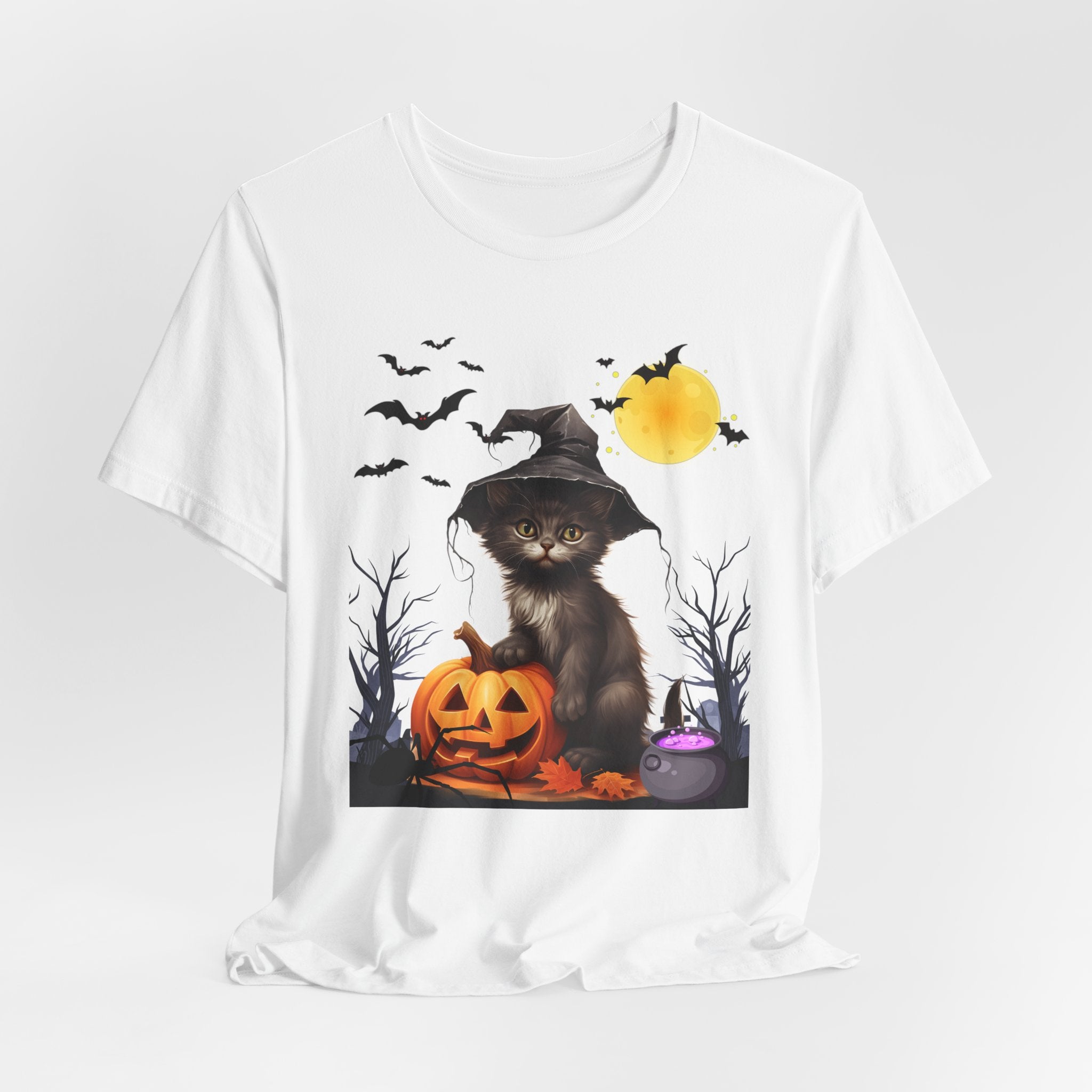 White t-shirt with a Halloween-themed design featuring a cat in a witch hat and pumpkins on a white background.