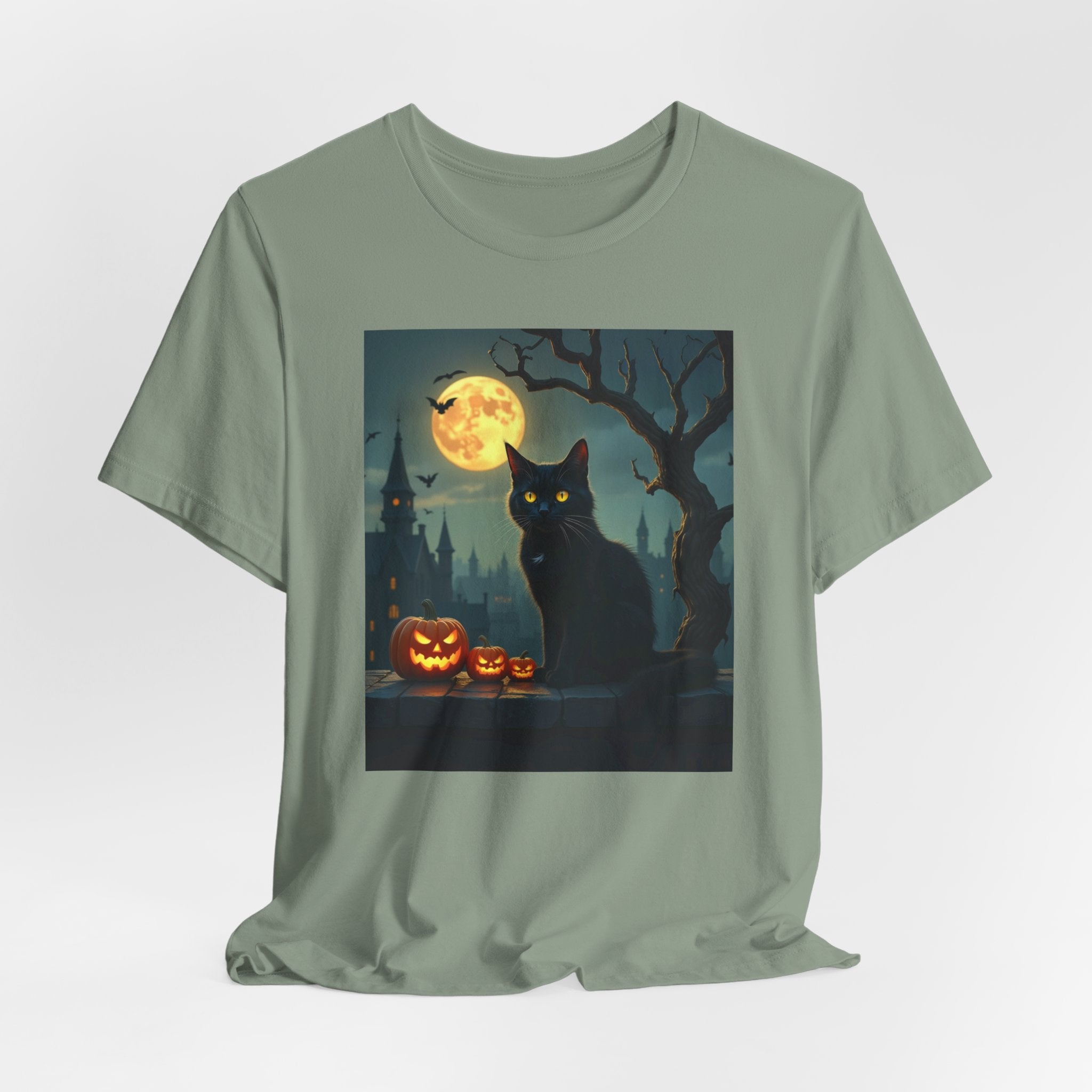 Sage green t-shirt with a Halloween design featuring a black cat, pumpkins, and a full moon.