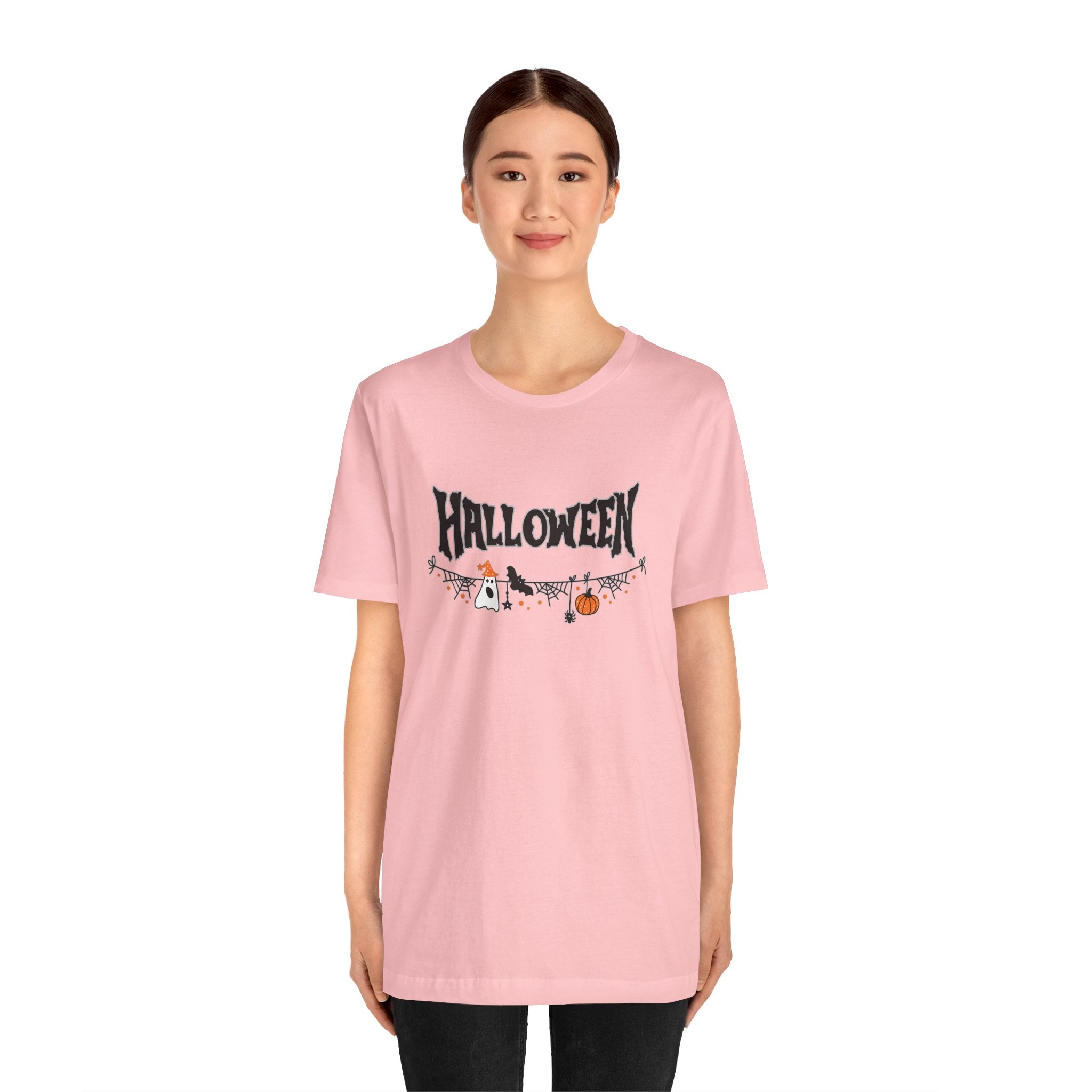 Person wearing a pink 'Halloween' t-shirt with a design on a white background