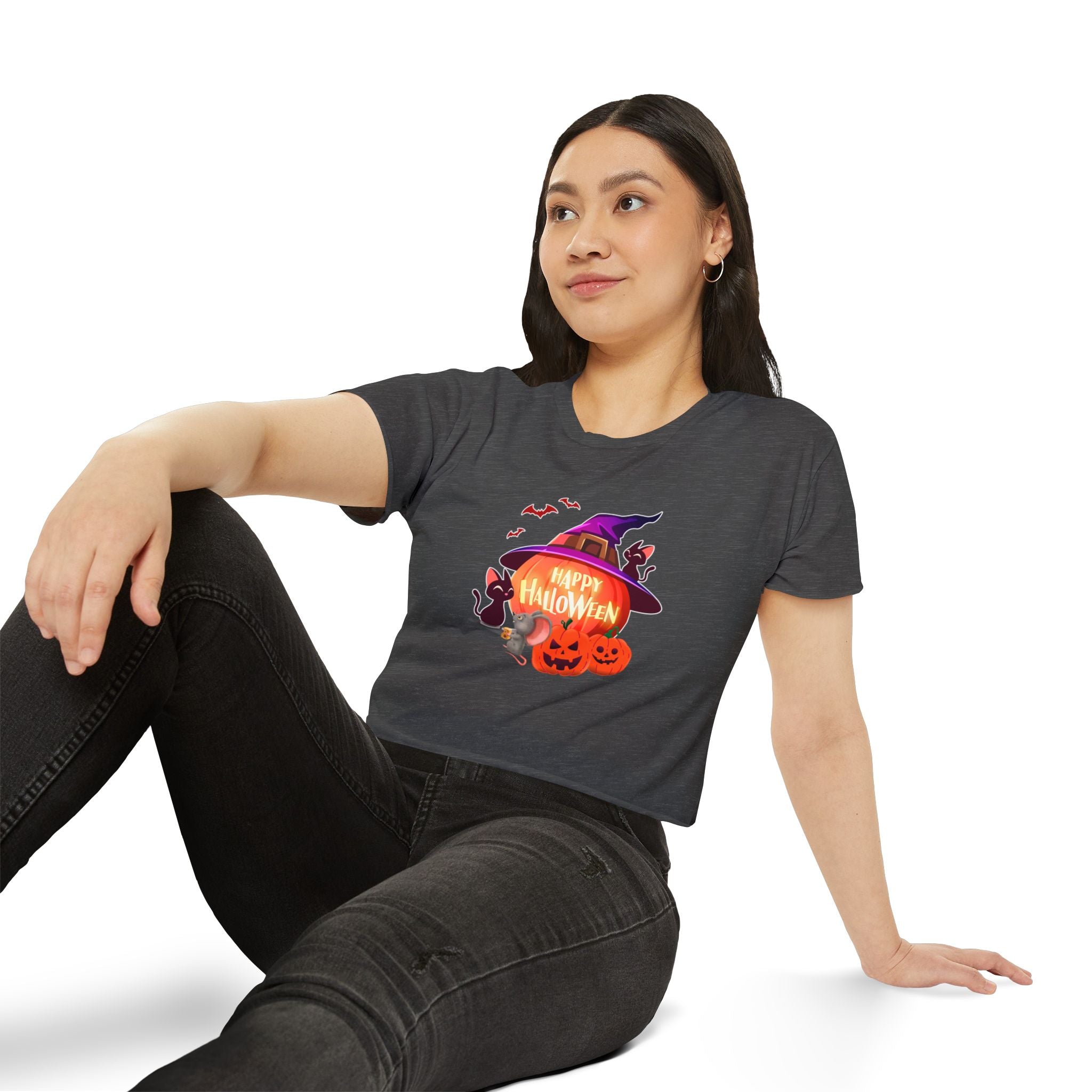 A seating woman wearing stonewash denim crop top shirt printed in halloween theme. 