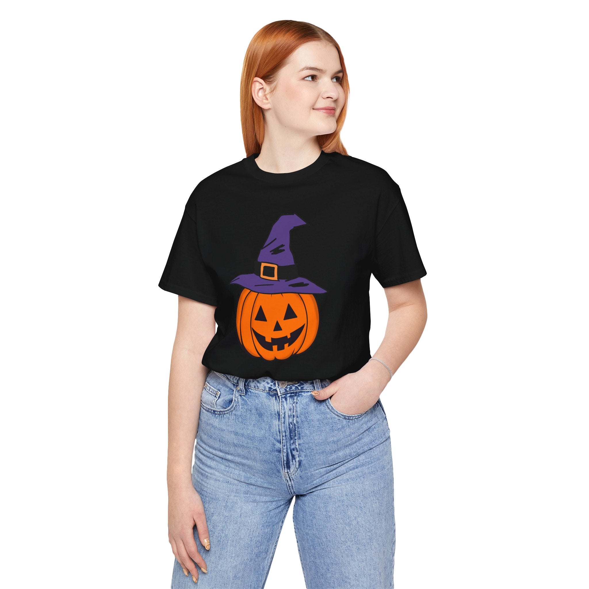 Person wearing a black t-shirt with a Halloween pumpkin design on a white background