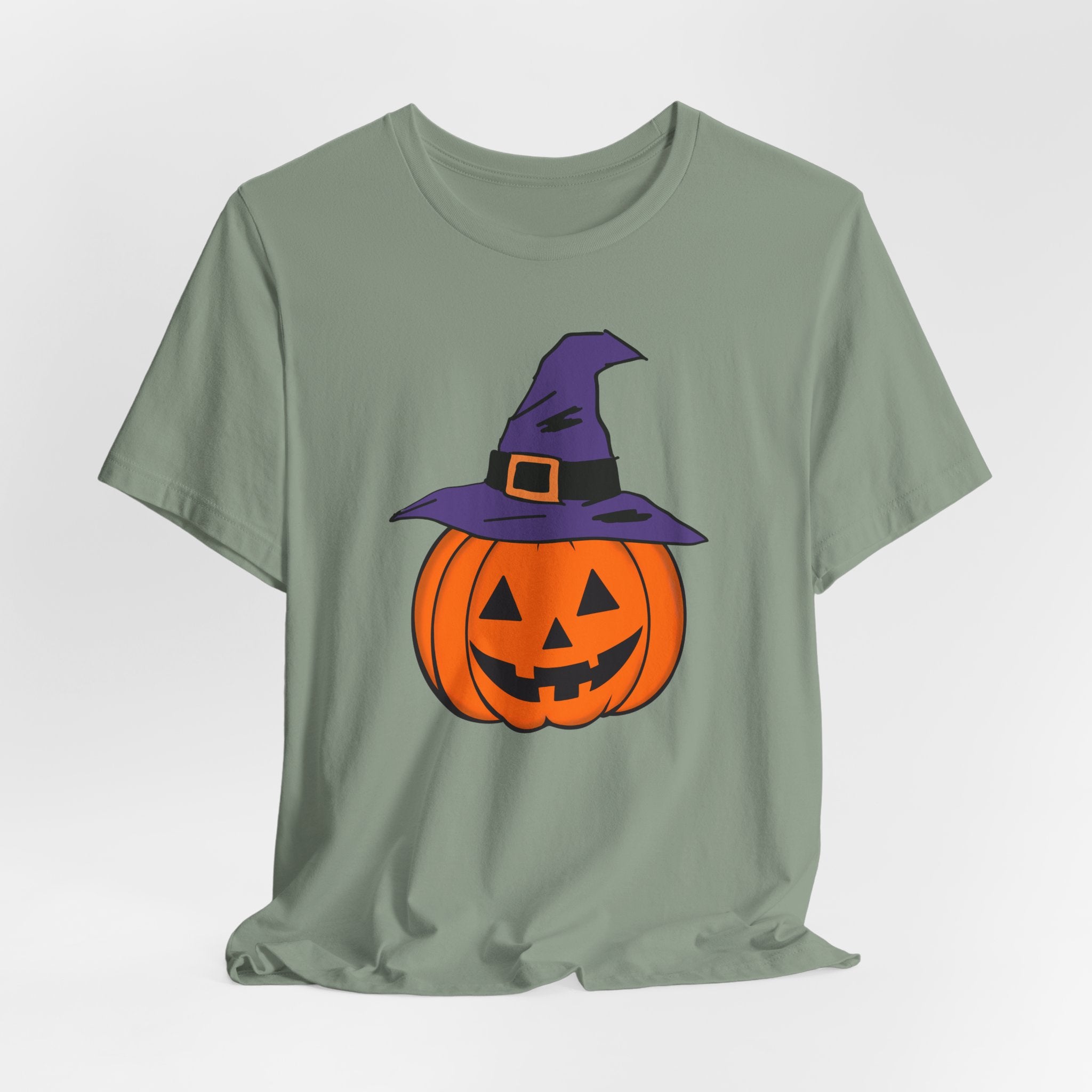 Sage green t-shirt with a Halloween-themed pumpkin graphic on a light gray background