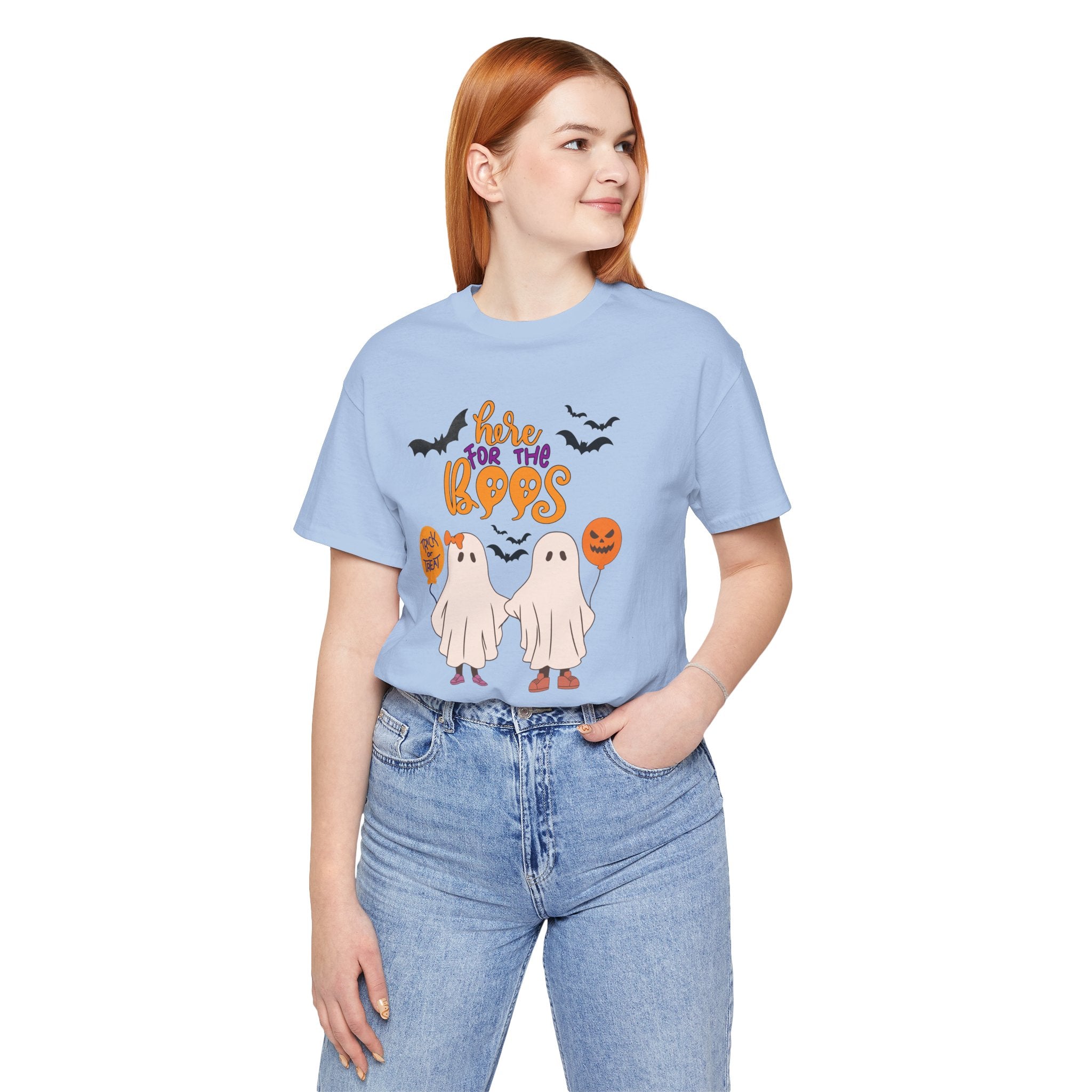 Person wearing a light blue t-shirt with Halloween graphics on a white background
