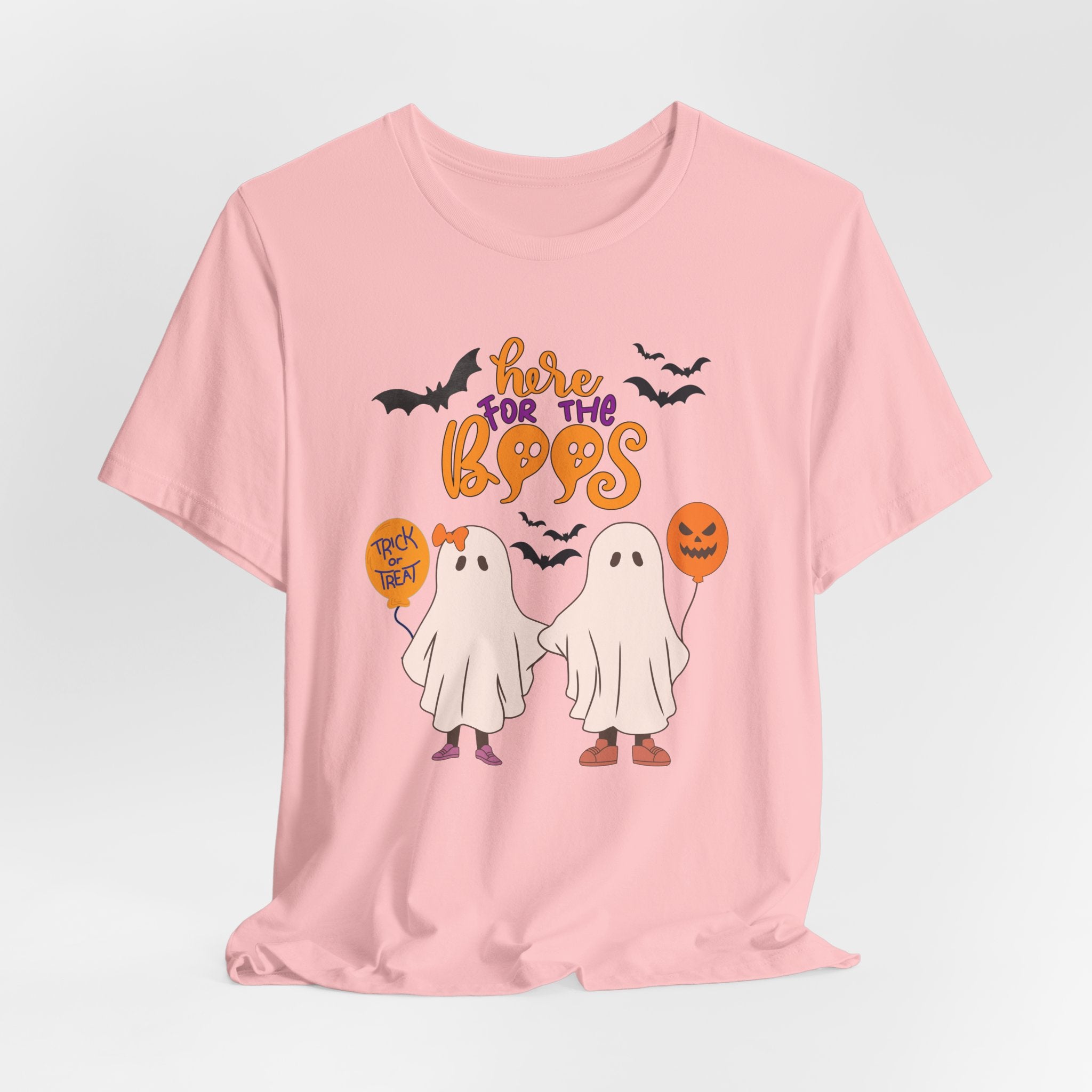 Pink t-shirt with Halloween-themed graphics and text on a light gray background