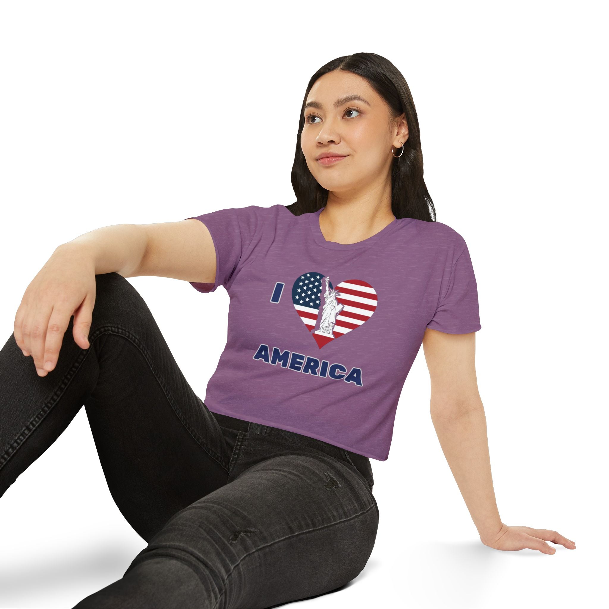 Woman wearing a purple t-shirt with 'I ❤️ AMERICA' design, sitting on a white background