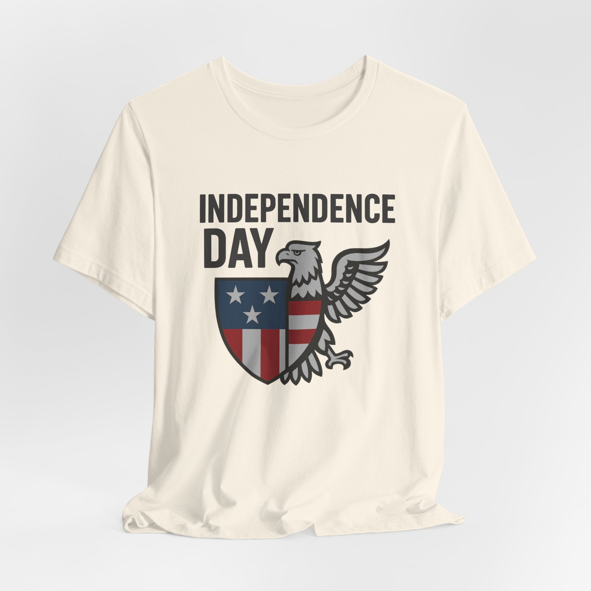 Ivory beige t-shirt with 'Independence Day' graphic design featuring an eagle and shield on a light gray background