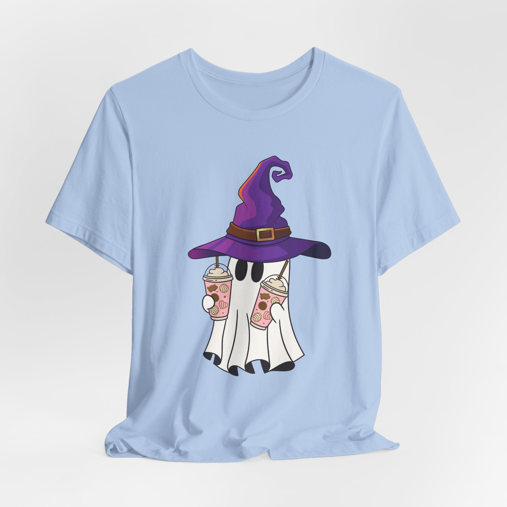Light blue t-shirt with ghost and purple witch hat graphic holding two cups of  juice on a light gray background 