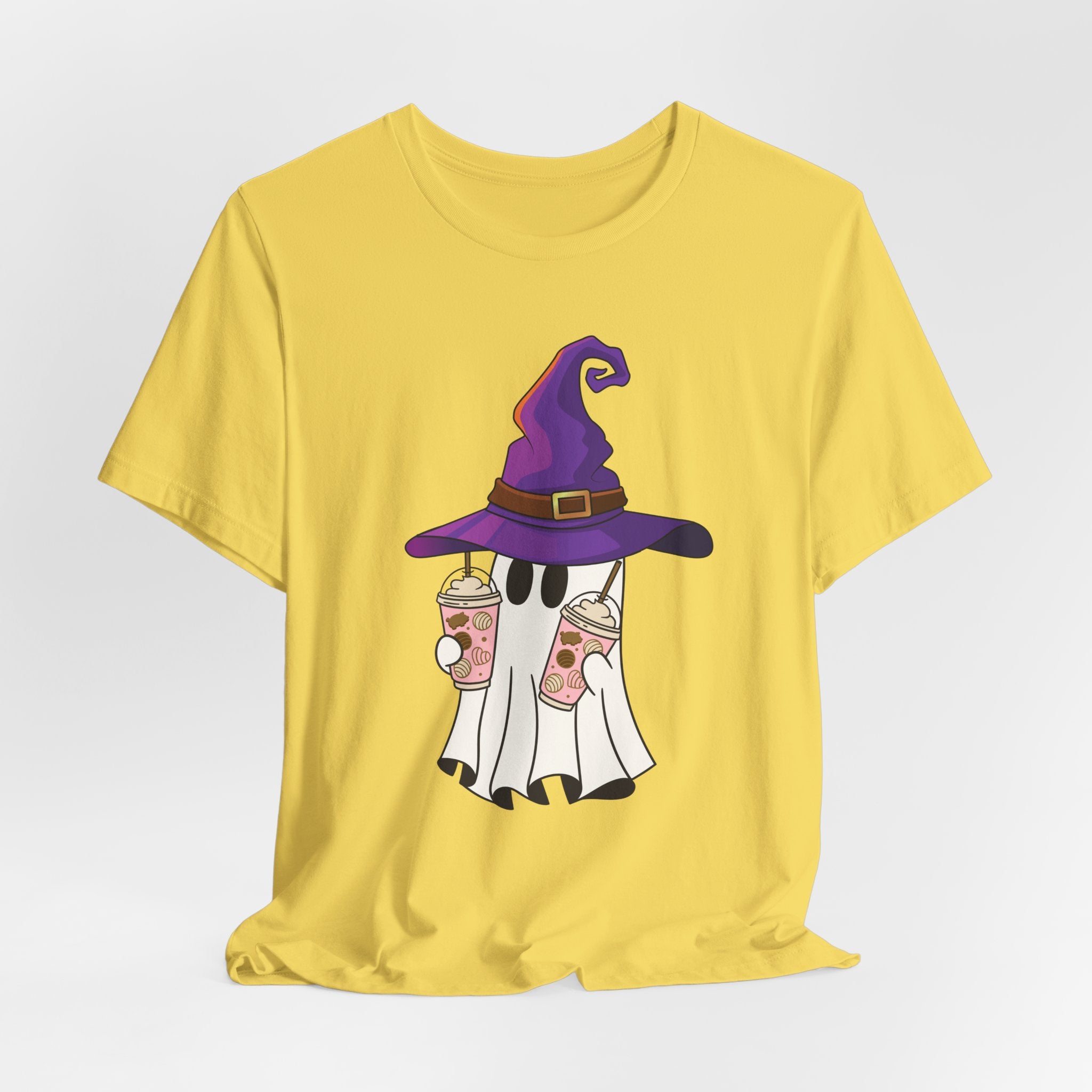 Maze yellow t-shirt with ghost and purple witch hat graphic holding two cups of  juice on a light gray background 