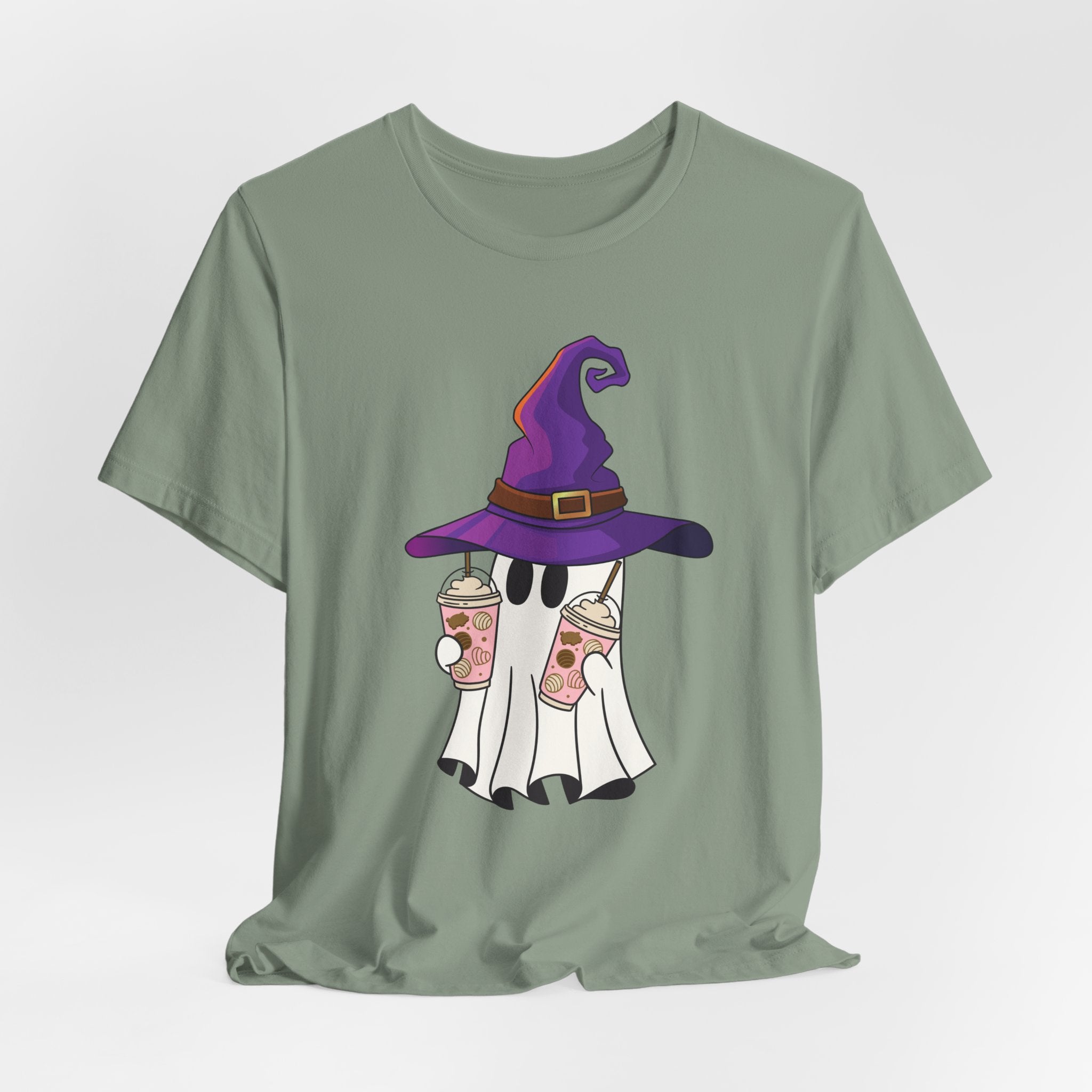 Sage green t-shirt with ghost and purple witch hat graphic holding two cups of  juice on a light gray background 