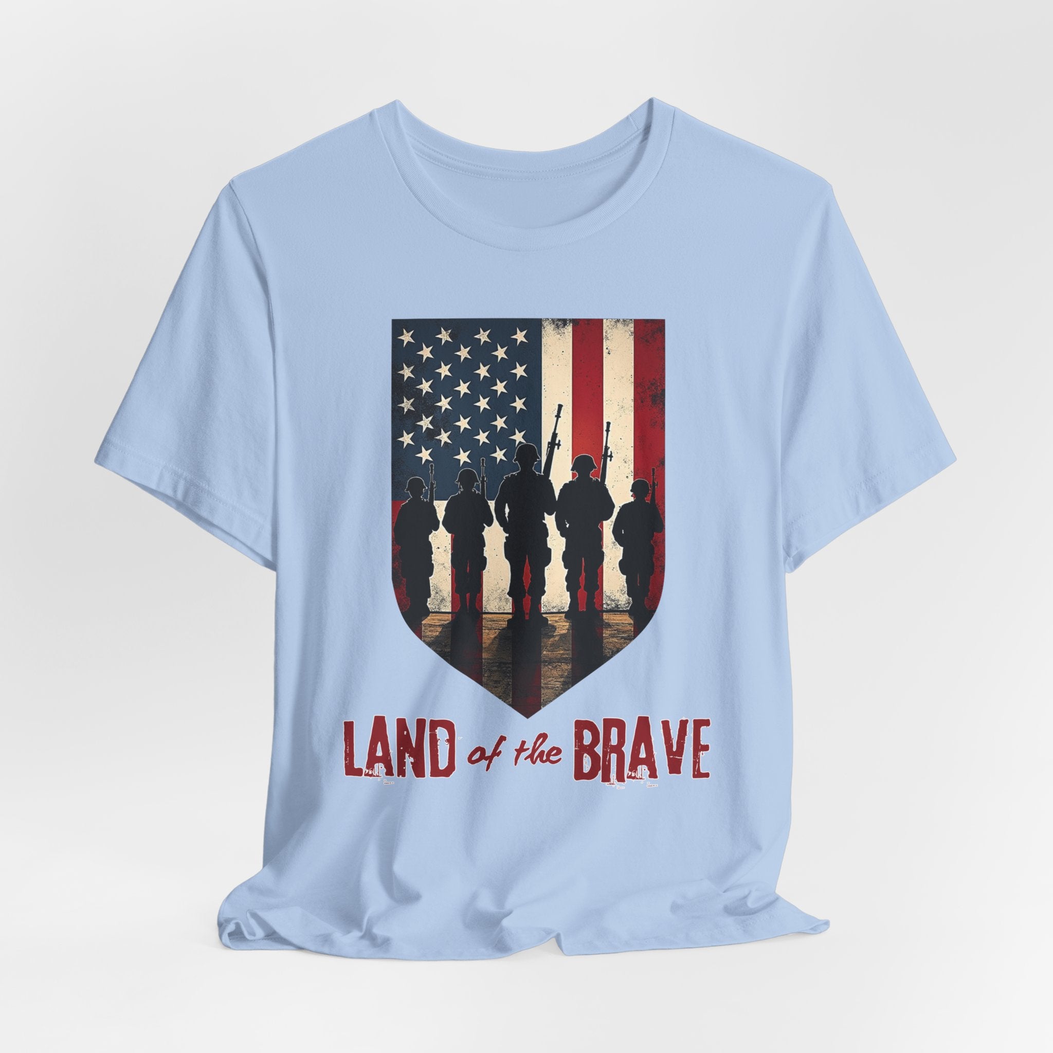 Light blue t-shirt with vintage American flag, soldiers, and silhouette design with land of the brave text on a white background