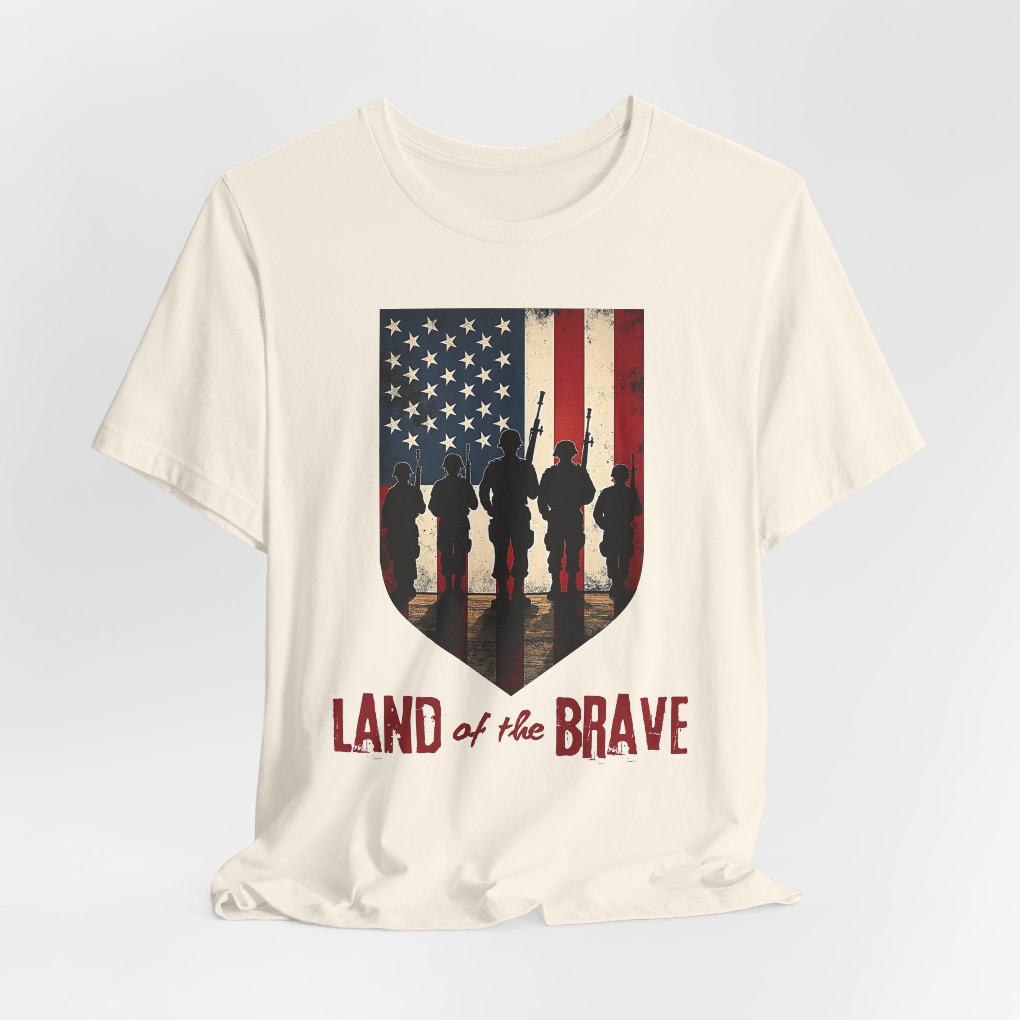 Ivory beige t-shirt with vintage American flag, soldiers, and silhouette design with land of the brave text on a white background