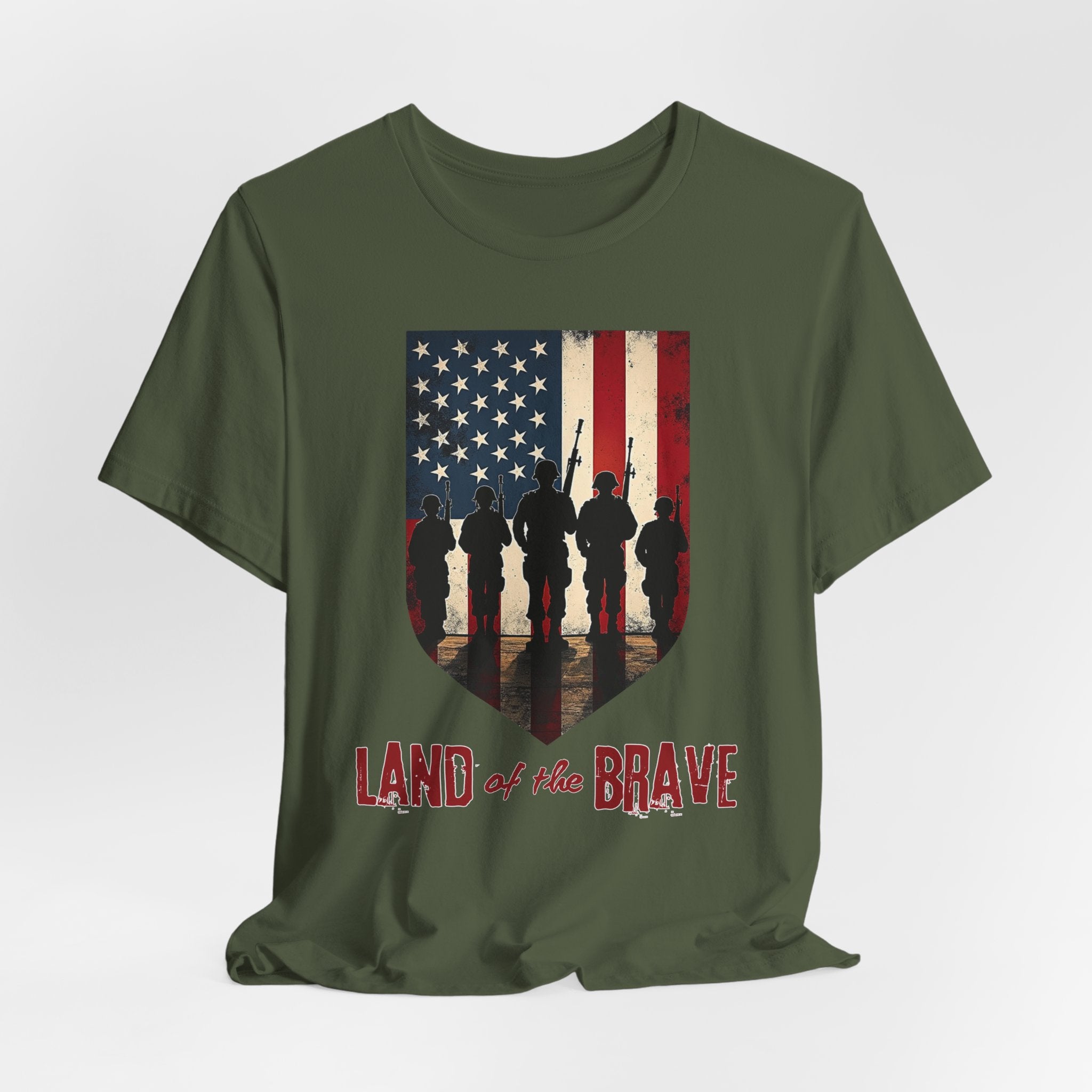 Military green t-shirt with vintage American flag, soldiers, and silhouette design with land of the brave text on a white background