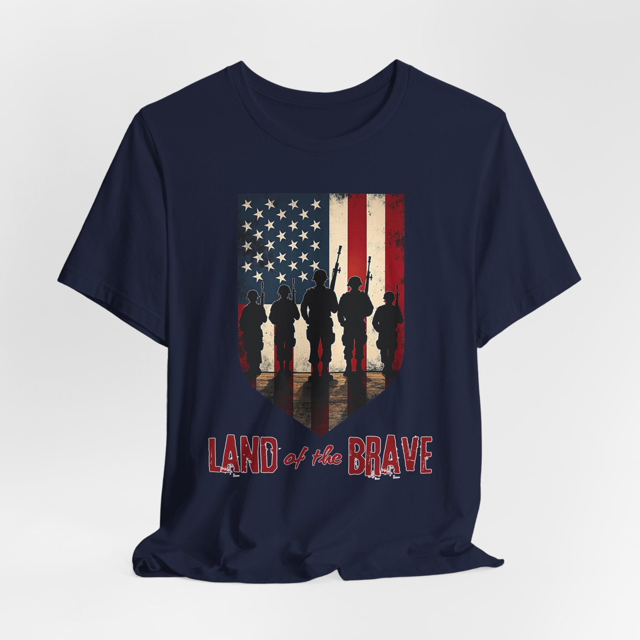 Navy blue t-shirt with vintage American flag, soldiers, and silhouette design with land of the brave text on a white background