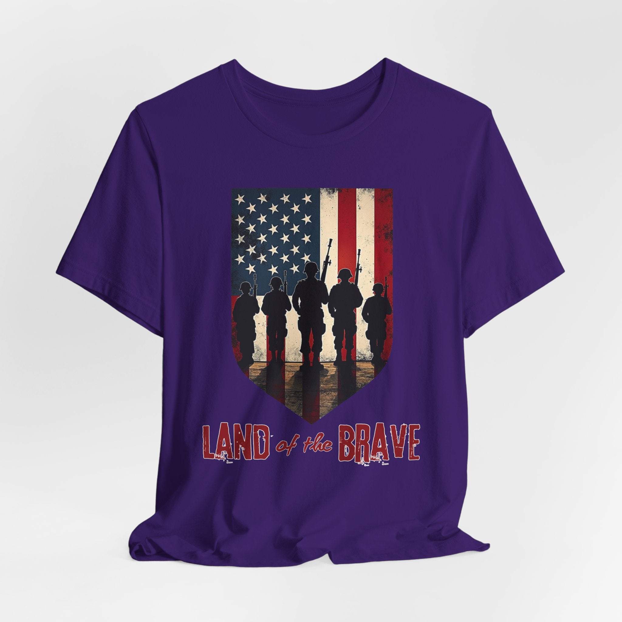 Purple t-shirt with vintage American flag, soldiers, and silhouette design with land of the brave text on a white background