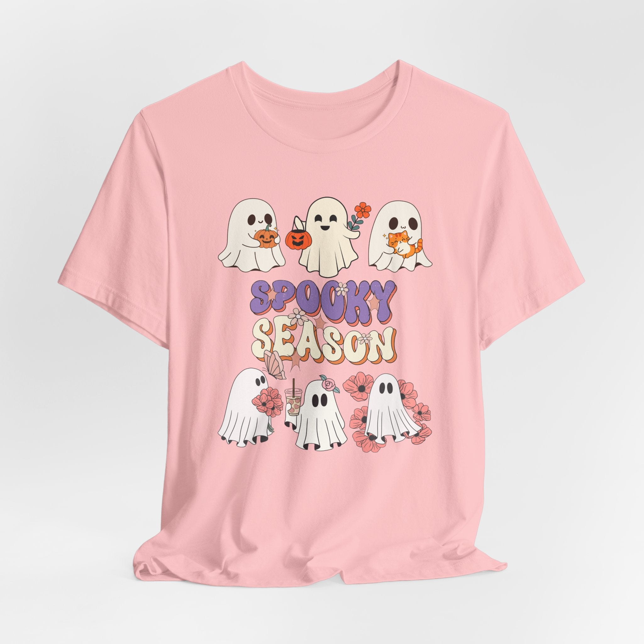 Pink t-shirt with cartoon ghosts and 'Spooky Season' text on a light gray background